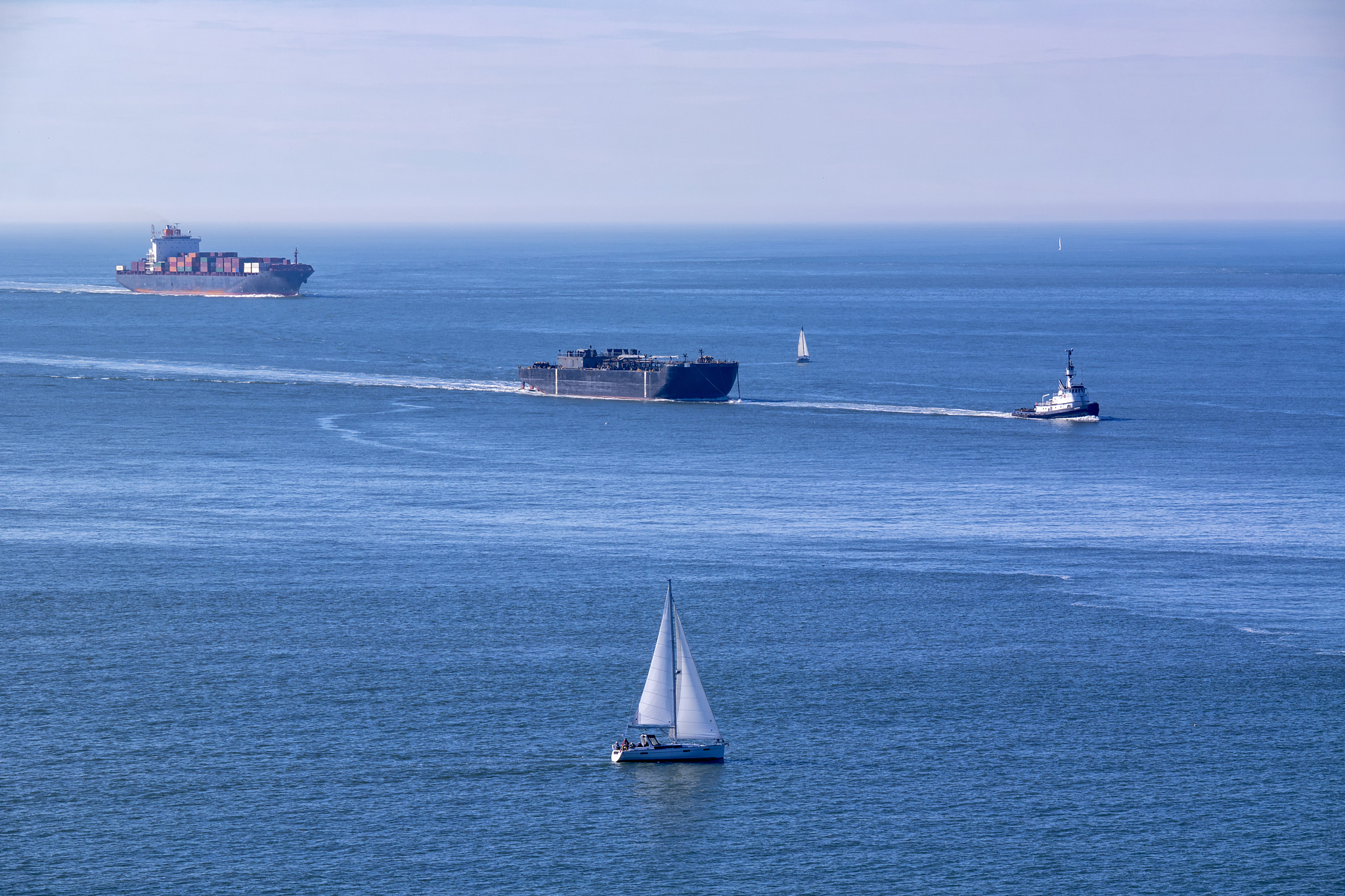 some ships and a tugboat towing a vessel.
