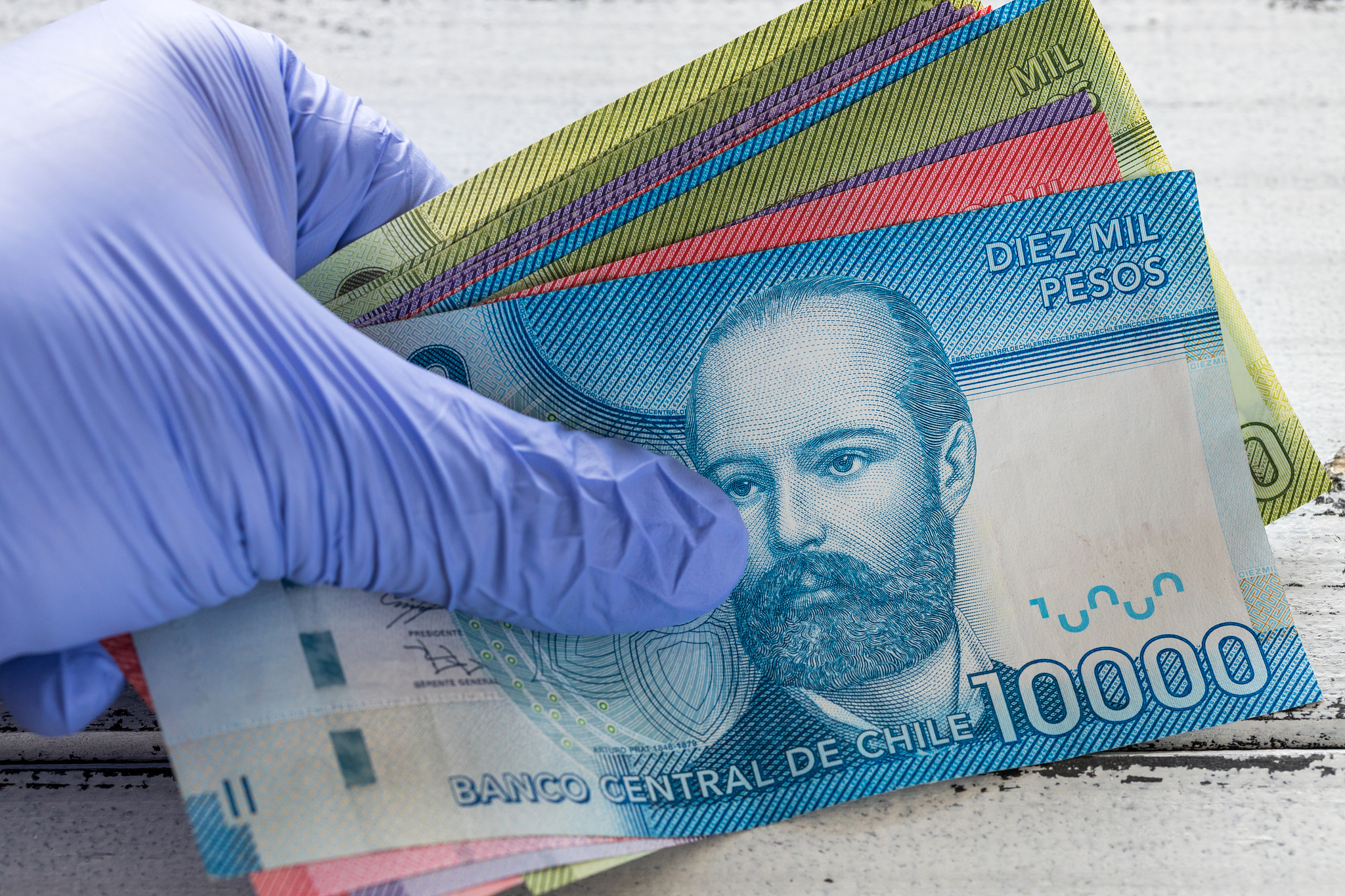 chile money, various banknotes kept in rubber gloves. the concep