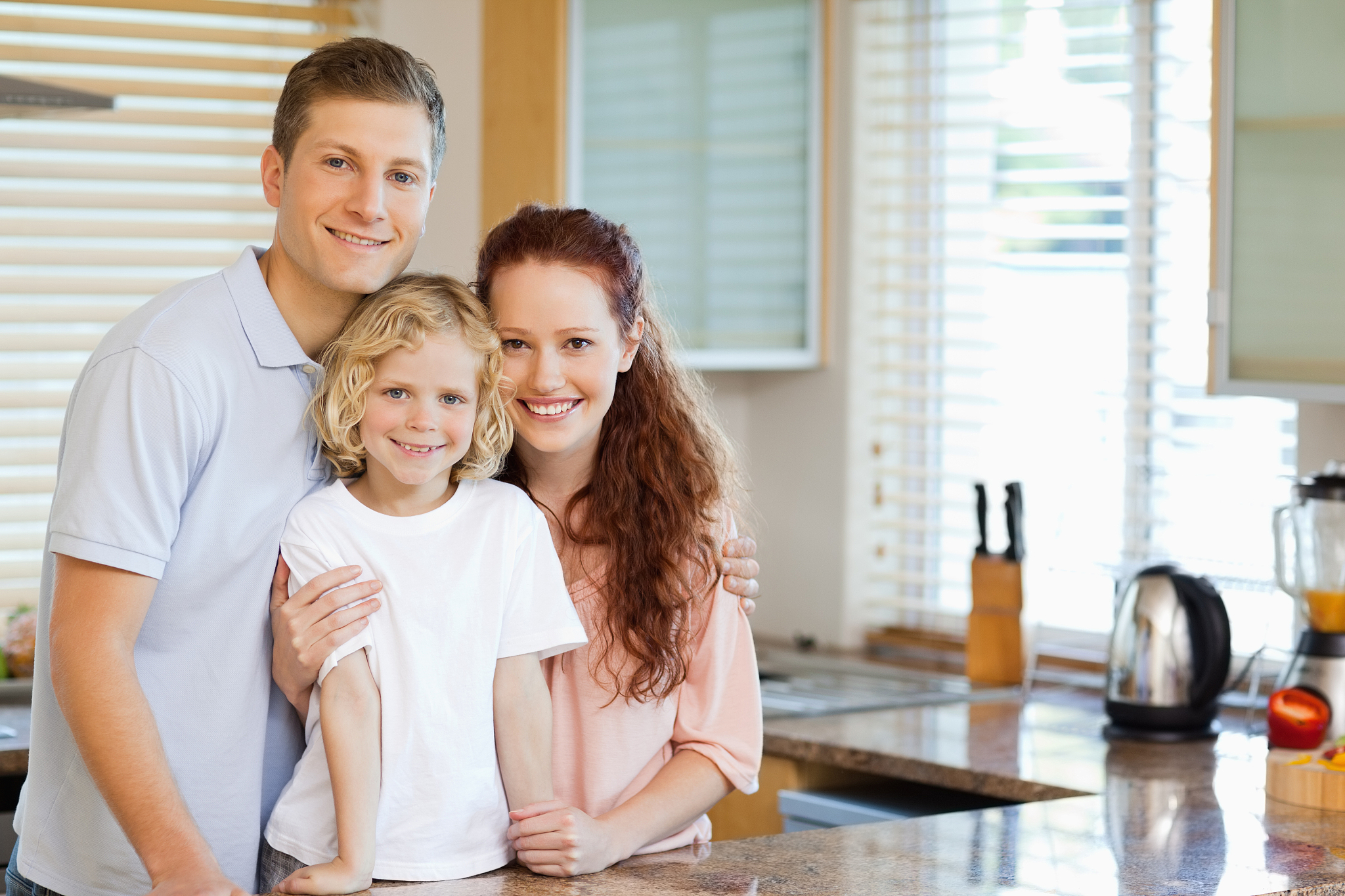 smiling family standing behind the kitchen counter