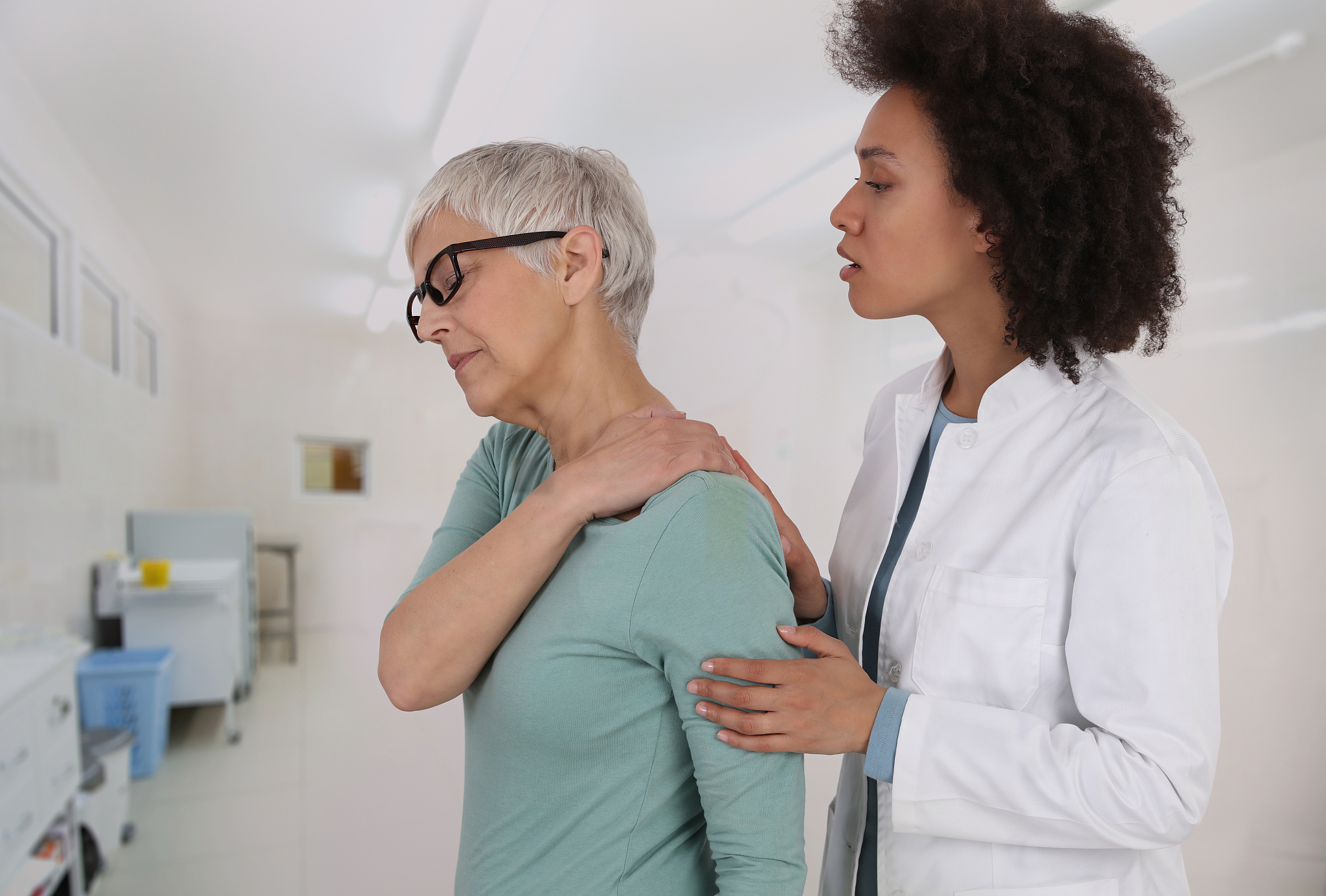 mature woman suffering from back pain during medical exam. chiro