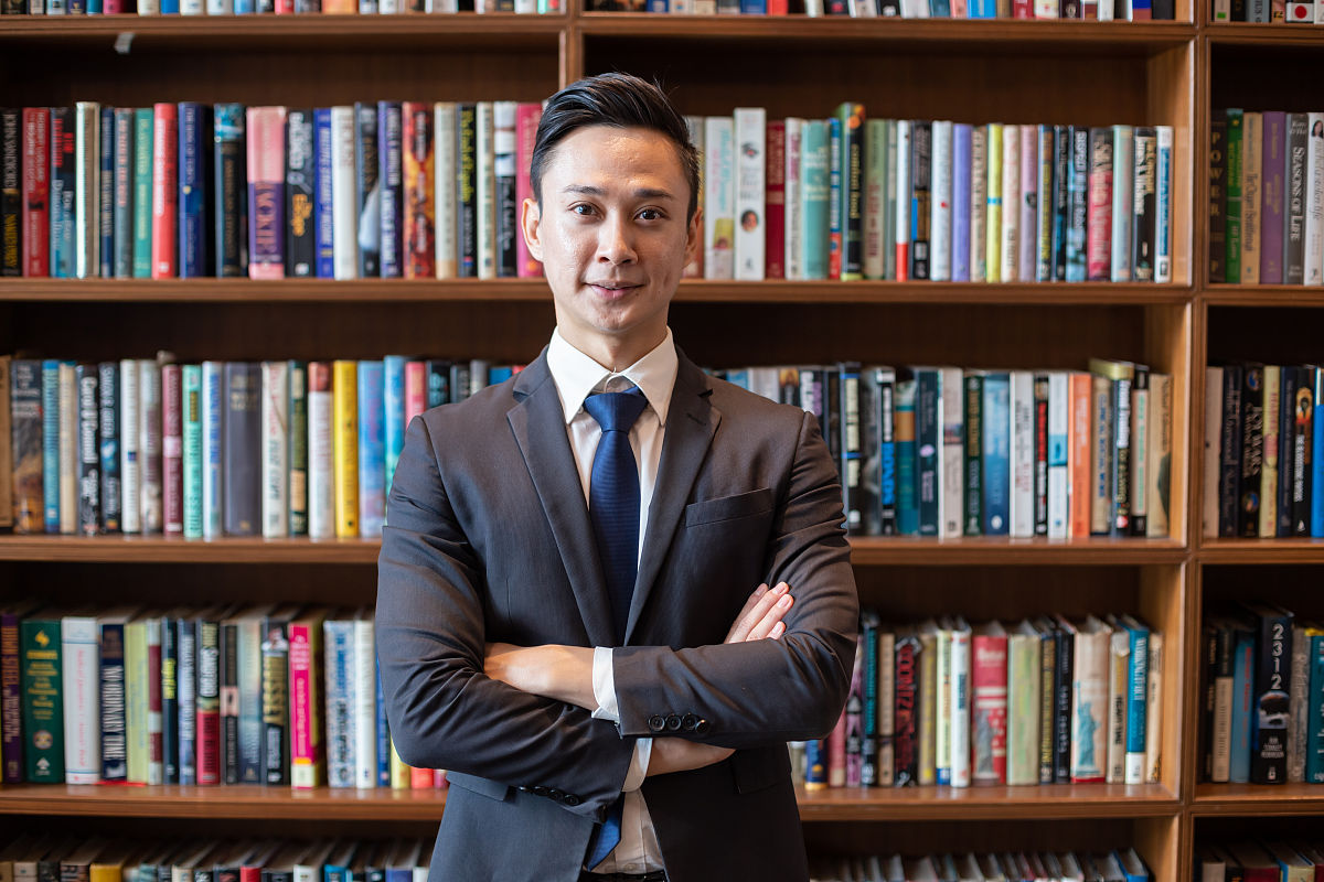 成功的商人站在书架前