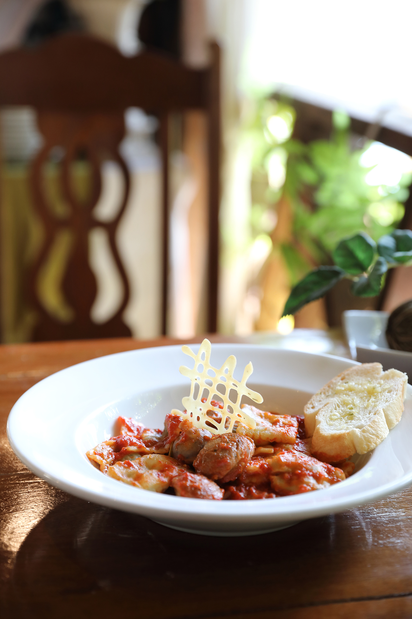 homemade spinach ravioli pasta with sausage in tomato sauce on w