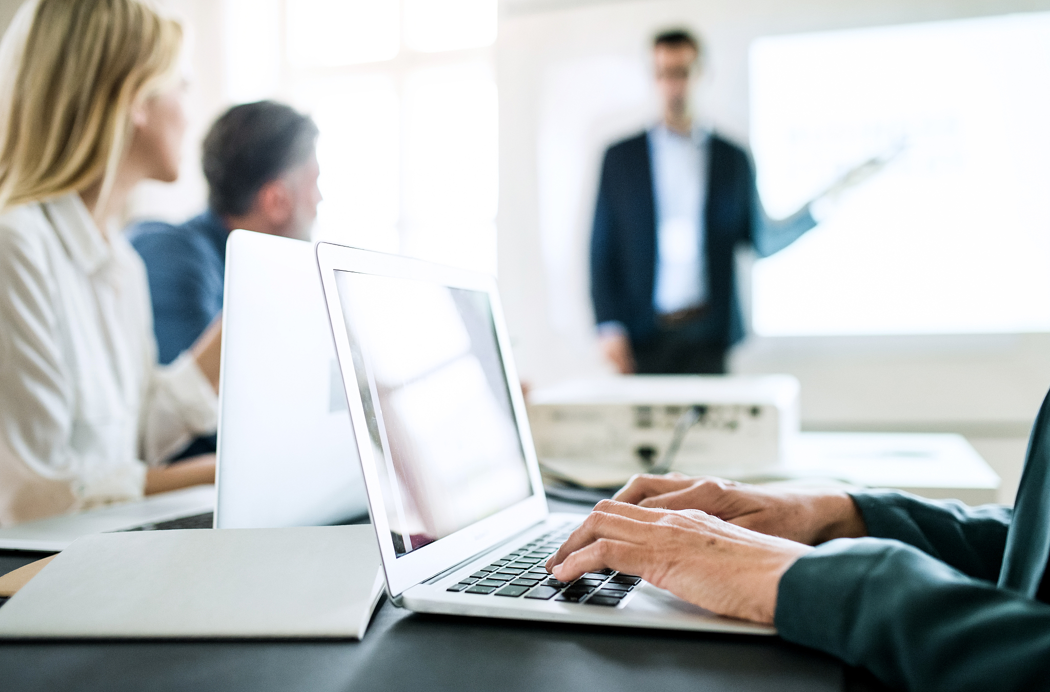 unrecognizable businesspeople with laptop sitting at the desk in