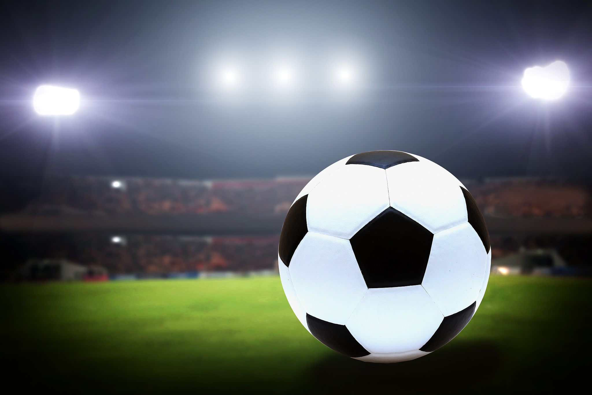 soccer ball on green field of football stadium