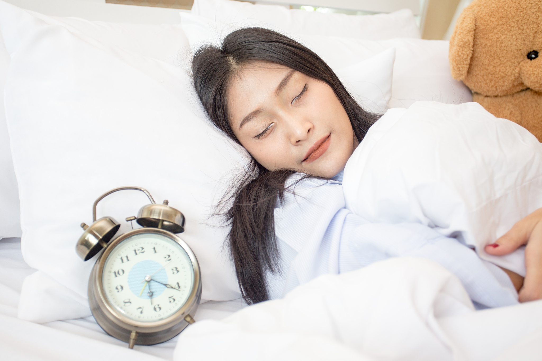 young asian sleeping woman and alarm clock in bedroom at home, w