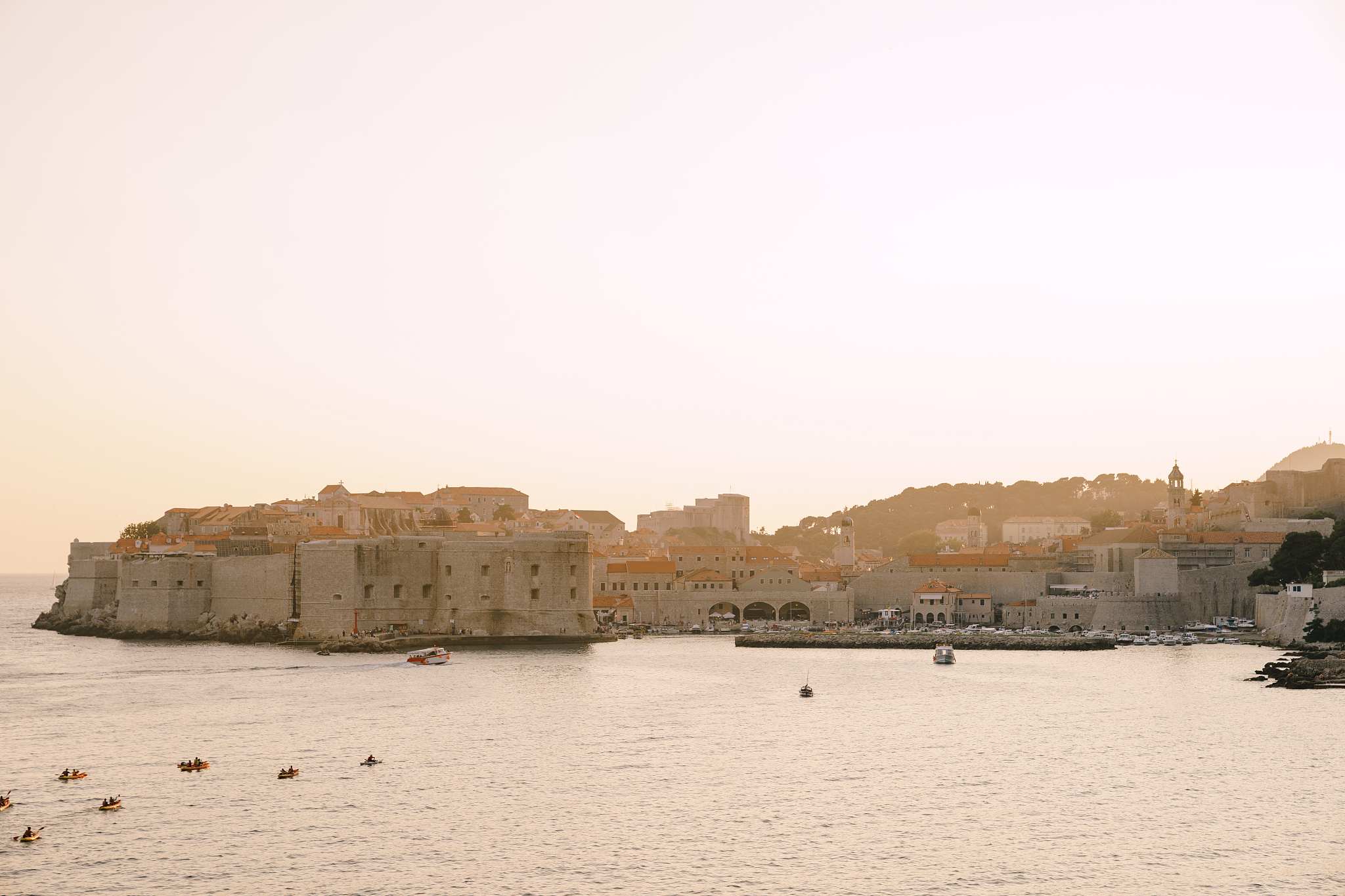the old city of dubrovnik against the sunset sky.