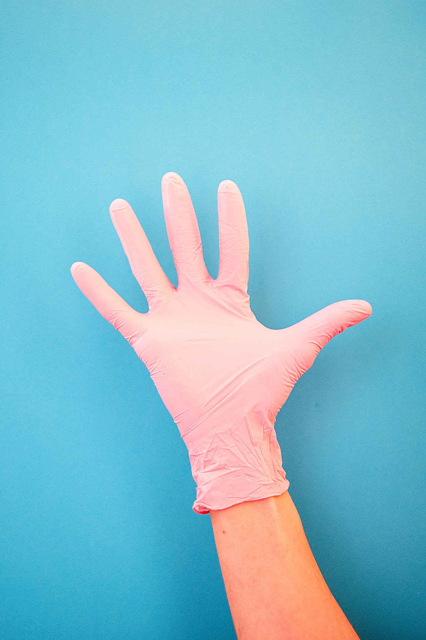 pointing a finger at number five, wearing pink medical gloves, a