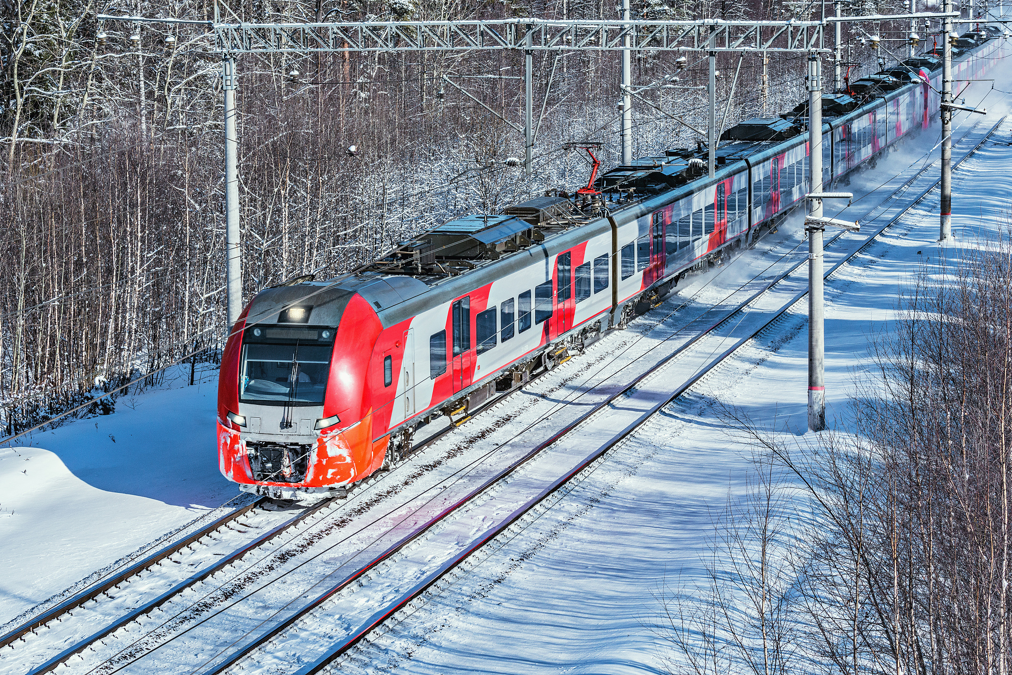 翻译以下内容：为了减少高速列车在高寒地区运行时转向架表面出现过多的积雪本文根据转向架舱形状和制动夹钳相对位置设计了两种主动吹气方案采用非定常雷诺平均算法与离散相模型耦合的方法对列车底部的风雪流进行计算以探究主动吹气对转向架区域的防雪效果。研究结果表明主动吹气改变了转向架区域的流线上扬现象和涡结构分布导致雪粒进入转向架区域的量减少；吹气还使作用在转向架舱端墙的压力增大作用方向与阻力方向相反降低了头车