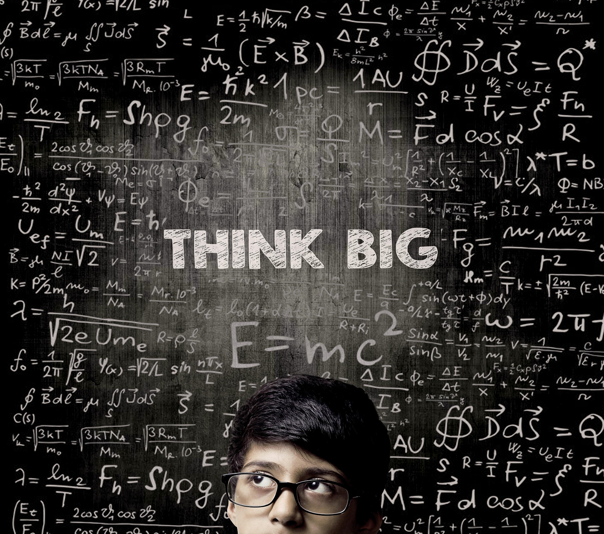 think big. half face genius boy thinking wearing glasses chalkbo