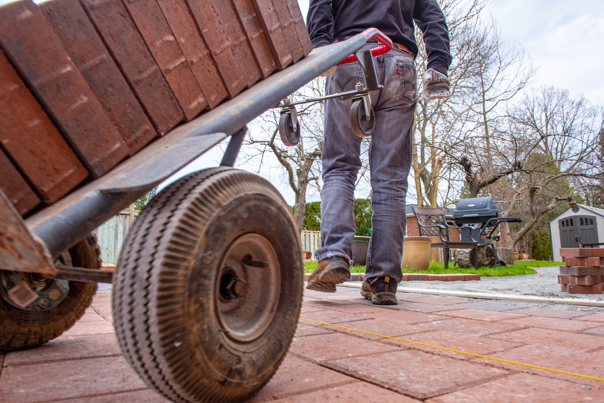 installing paver bricks for patio in backyard. a workman's glove