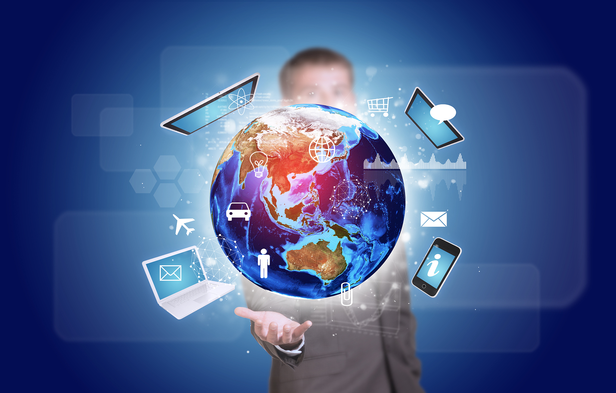 businessman in suit hold earth with electronics, graphs and icon