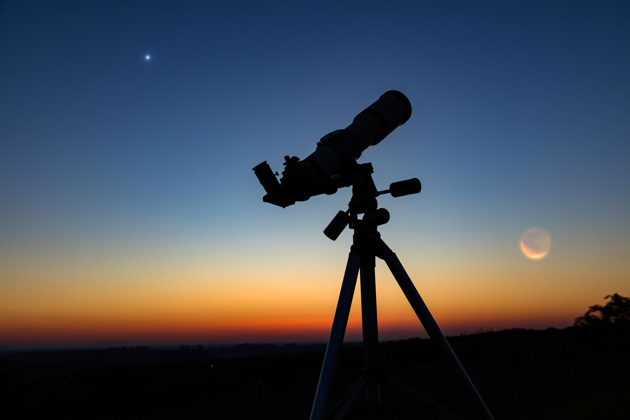 silhouette of a astronomy telescope with twilight sky.