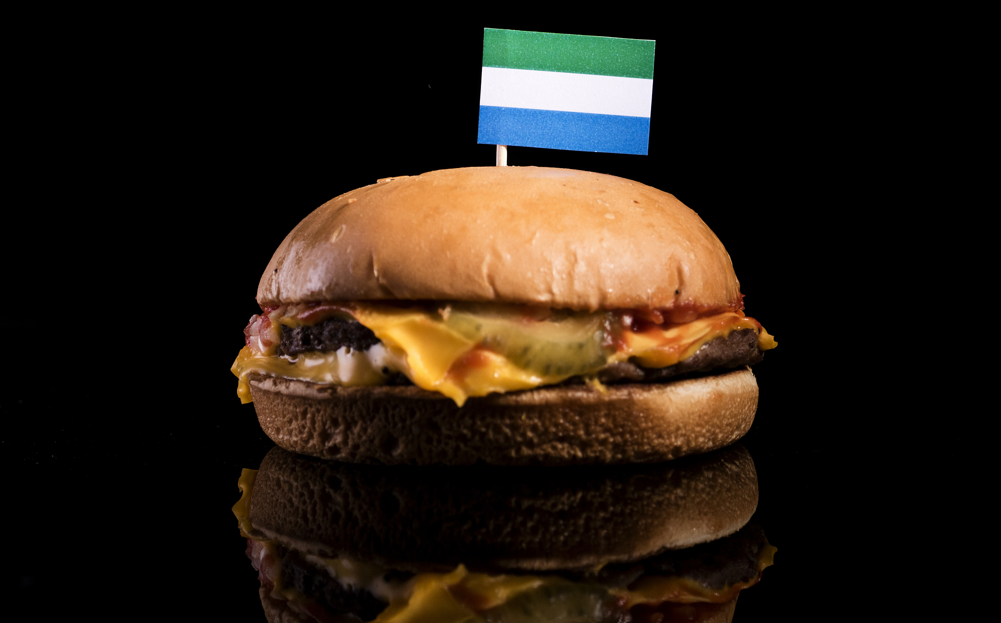 sierra leone flag on top of hamburger isolated on black backgrou
