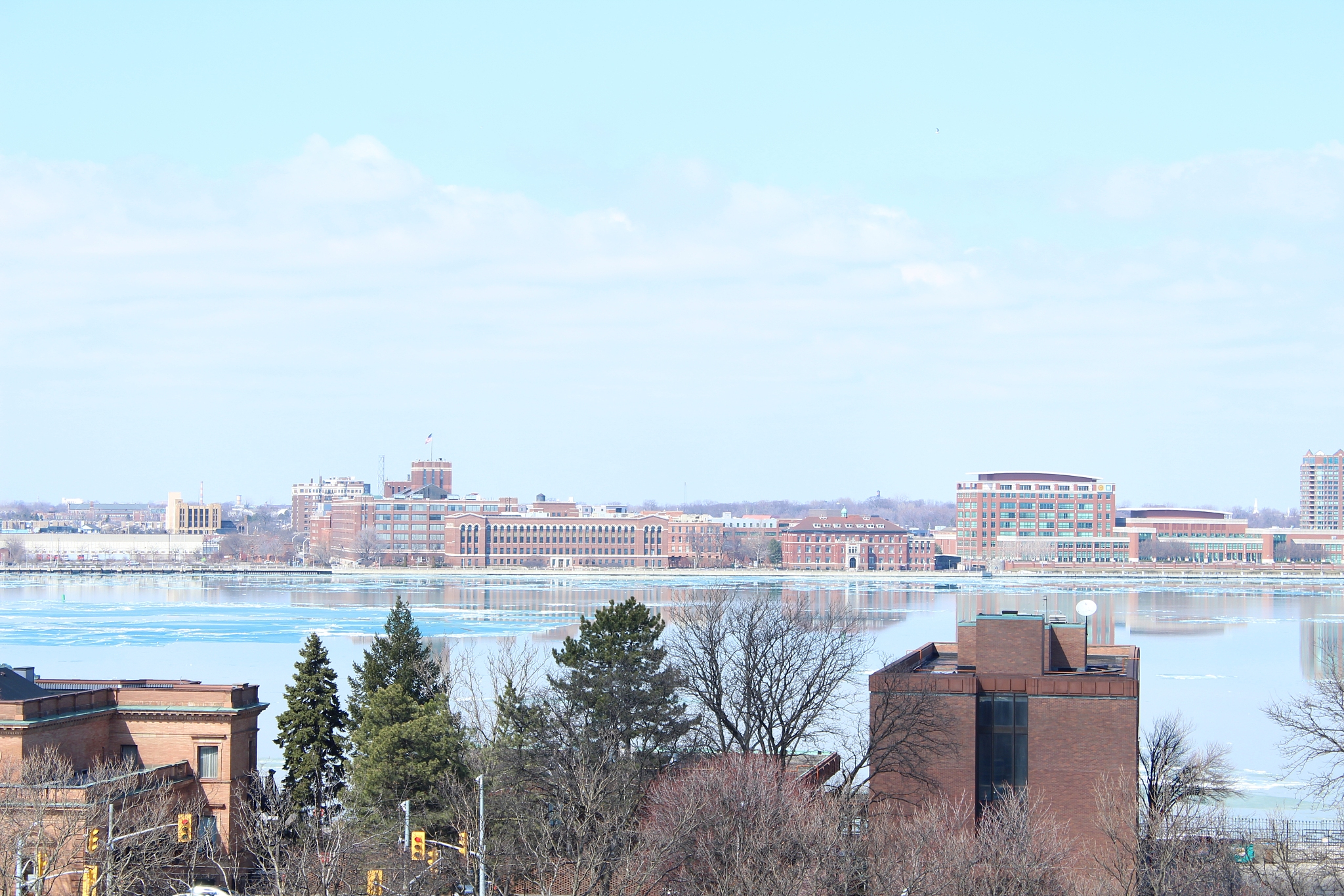 high angle view of buildings by river against sky