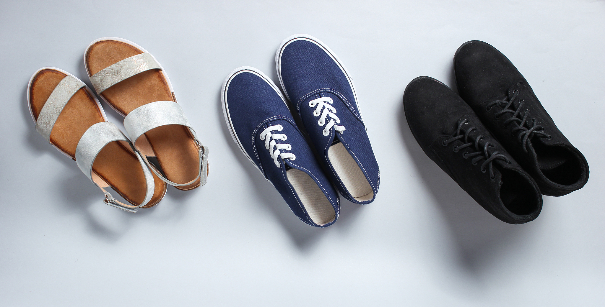 variety of seasonal shoes. sandals, boots, sneakers on a white b