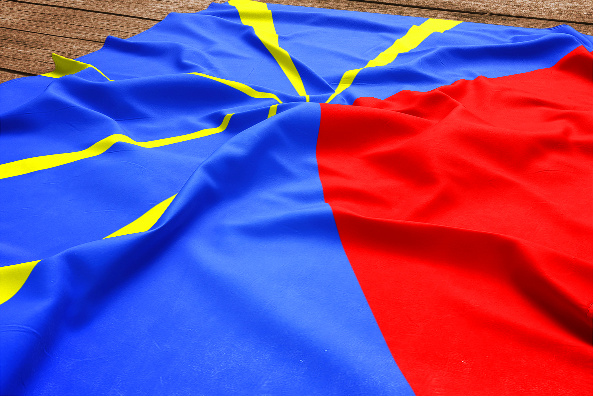 flag of reunion on a wooden desk background. silk flag top view.