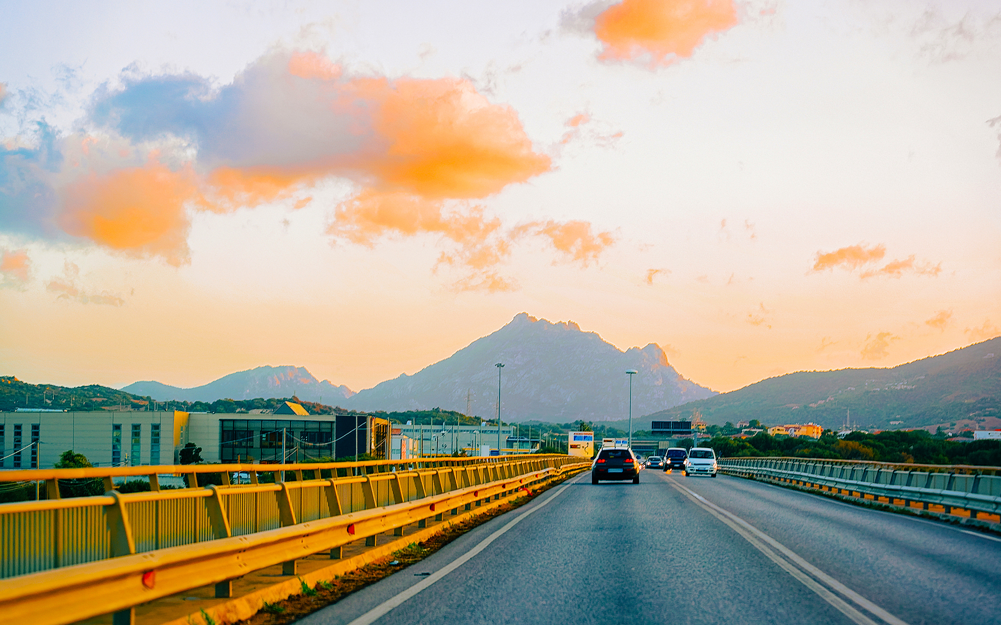 cars on summer road at sunset in olbia on sardinia