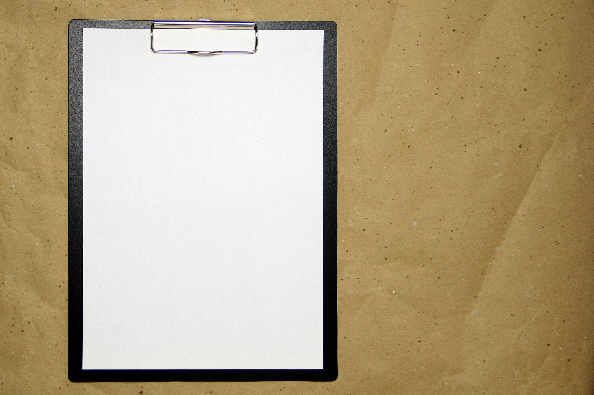 a tablet with a white sheet of a4 format on a beige craft paper
