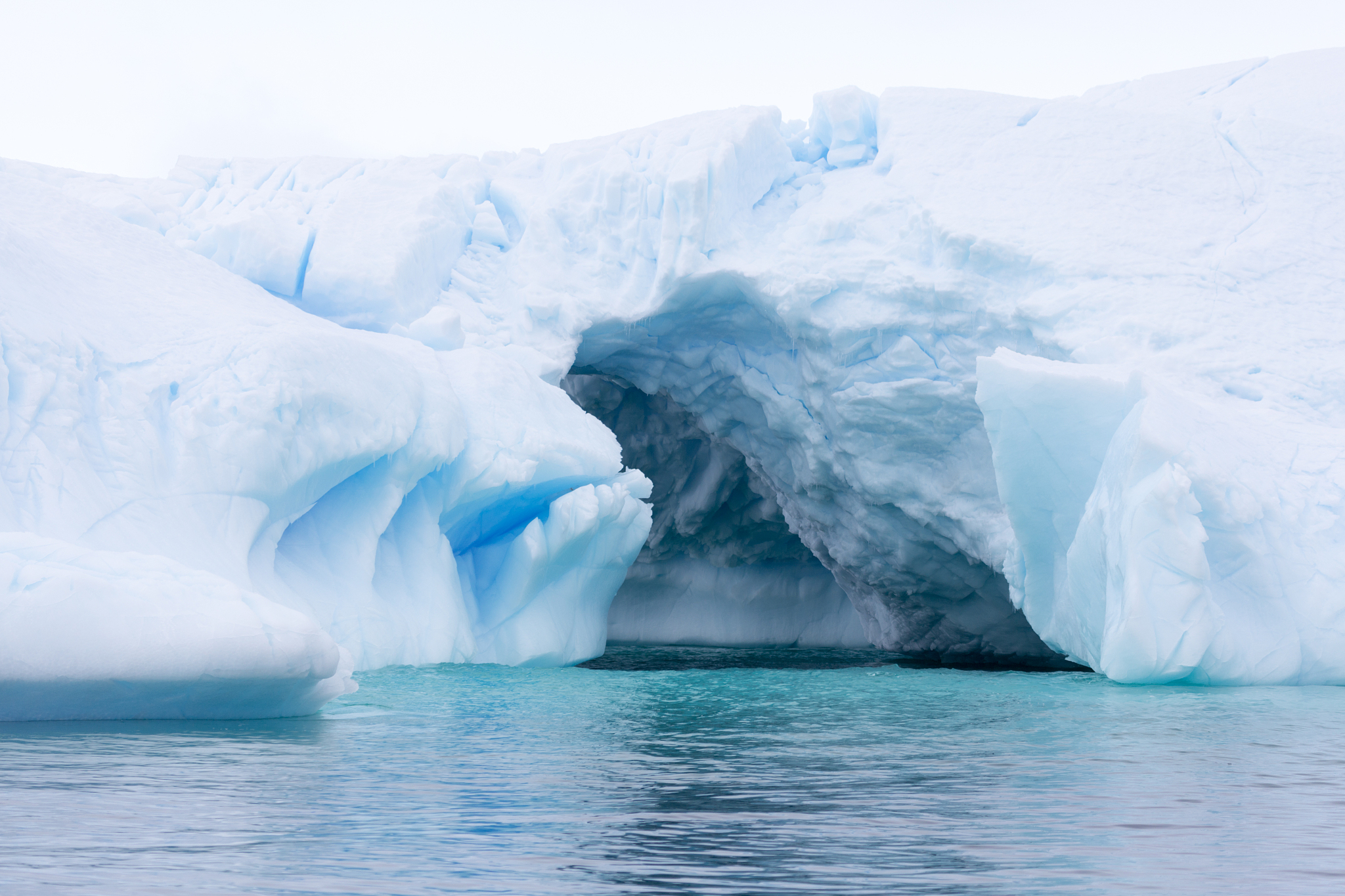 a huge cave has been carved in tho this iceberg.