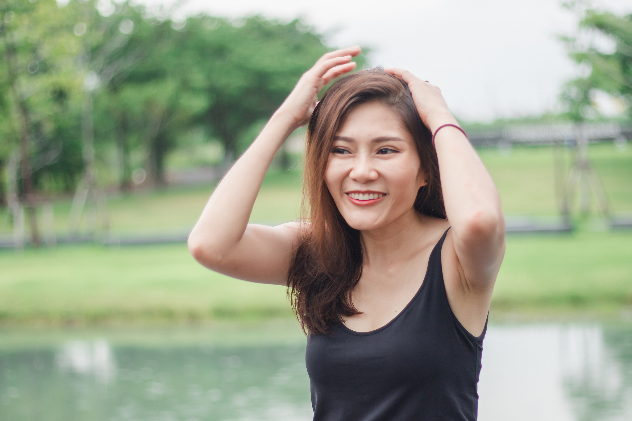 woman is holding her hair and smiling