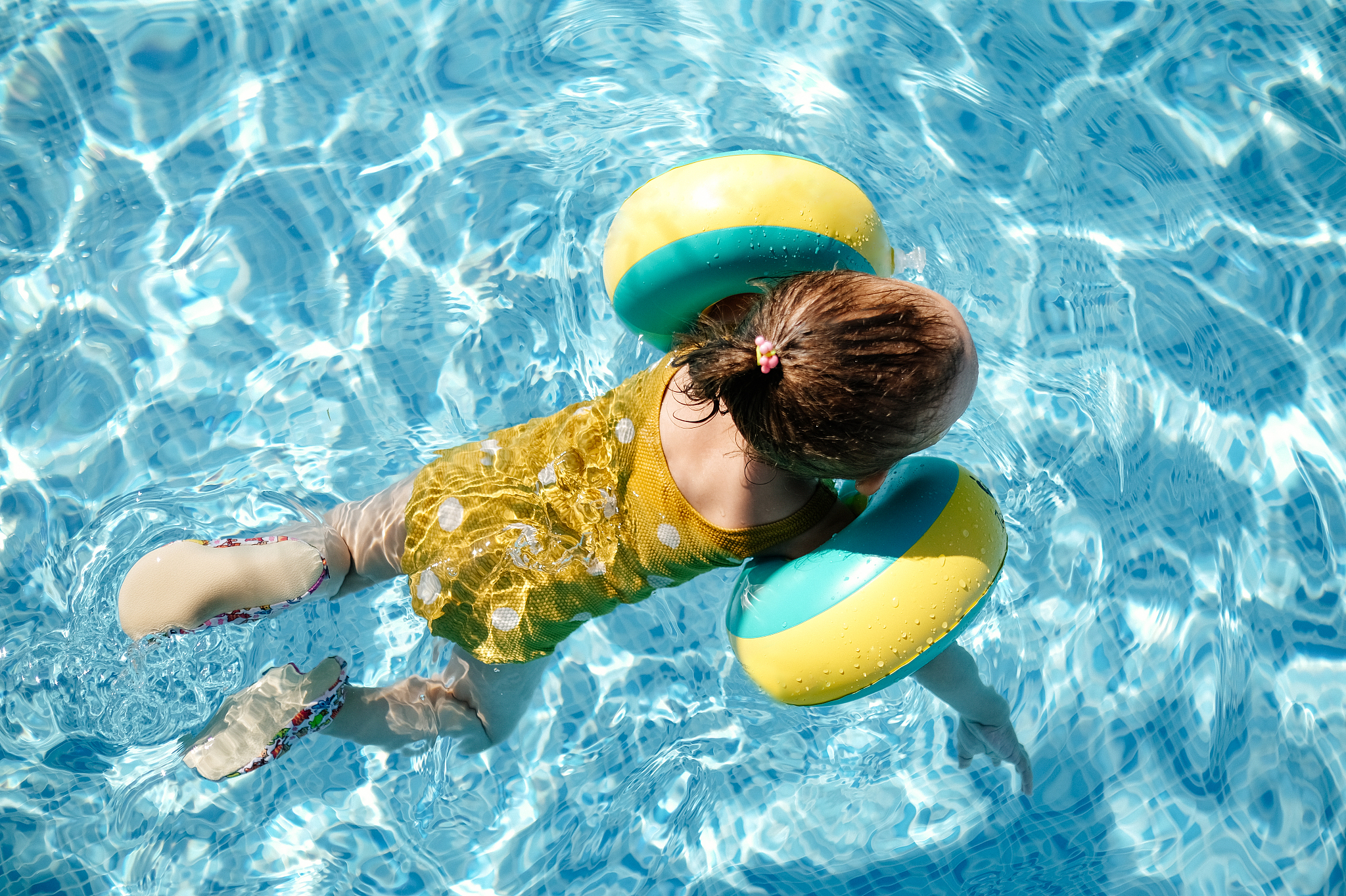 happy laughing toddler girl having fun in a swimming pool
