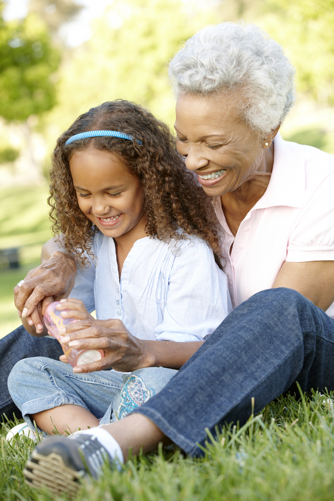 grandmother with granddaughter blowing bubbles in the park