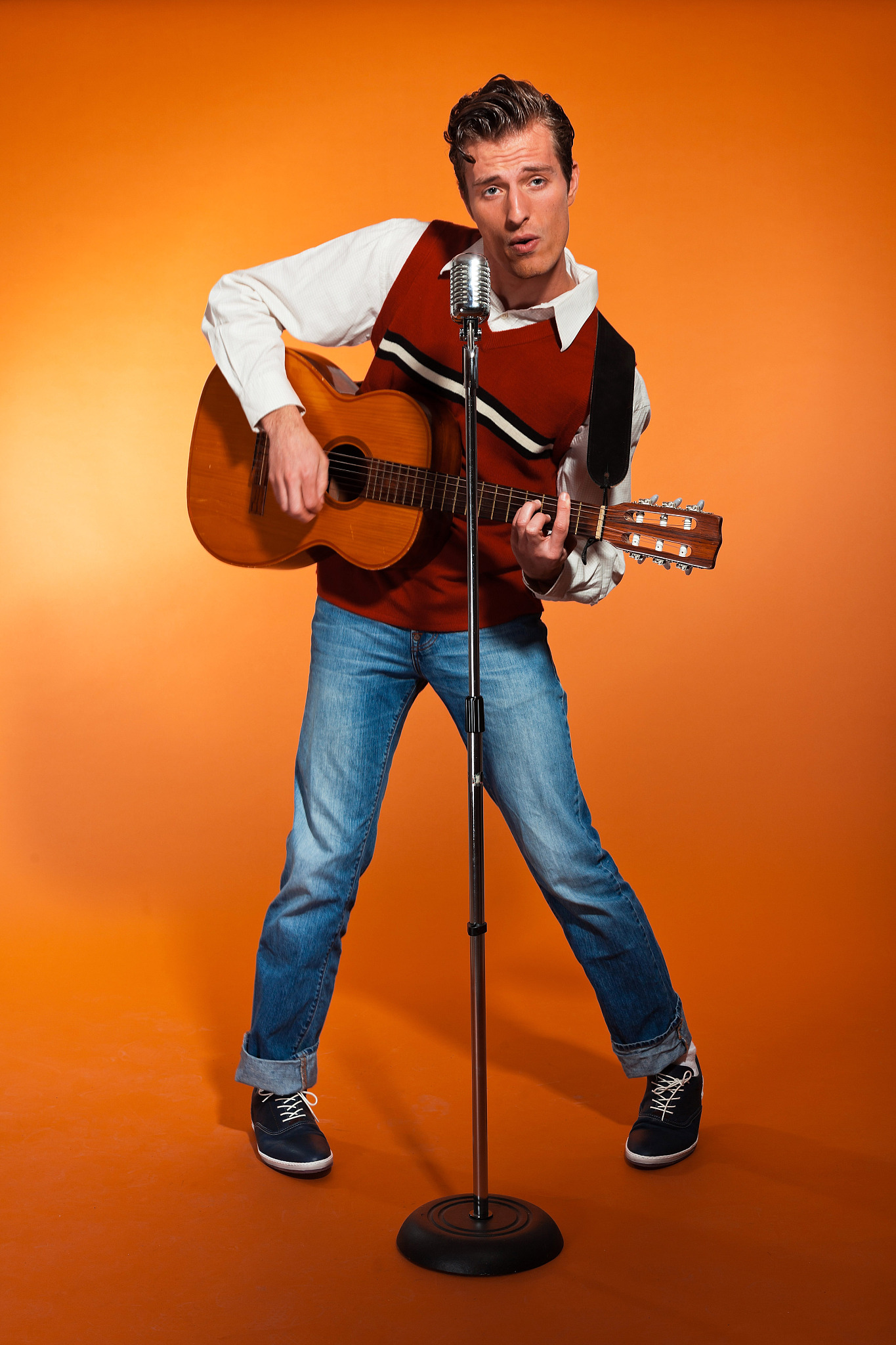 retro fifties rock and roll singer playing accoustic guitar.