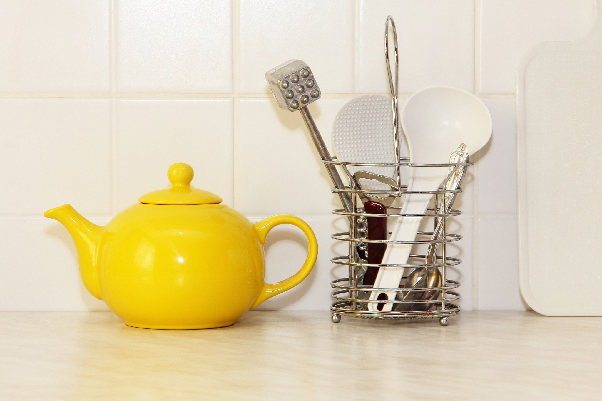 yellow ceramic teapot and utensil taken closeup.