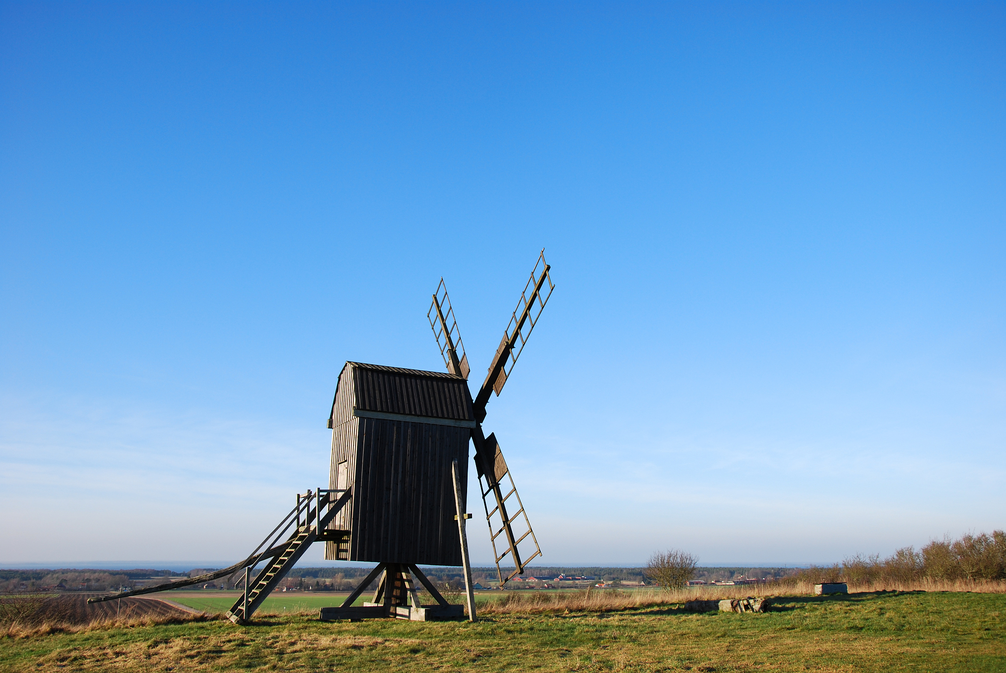 sunlit wooden windmill on a hill