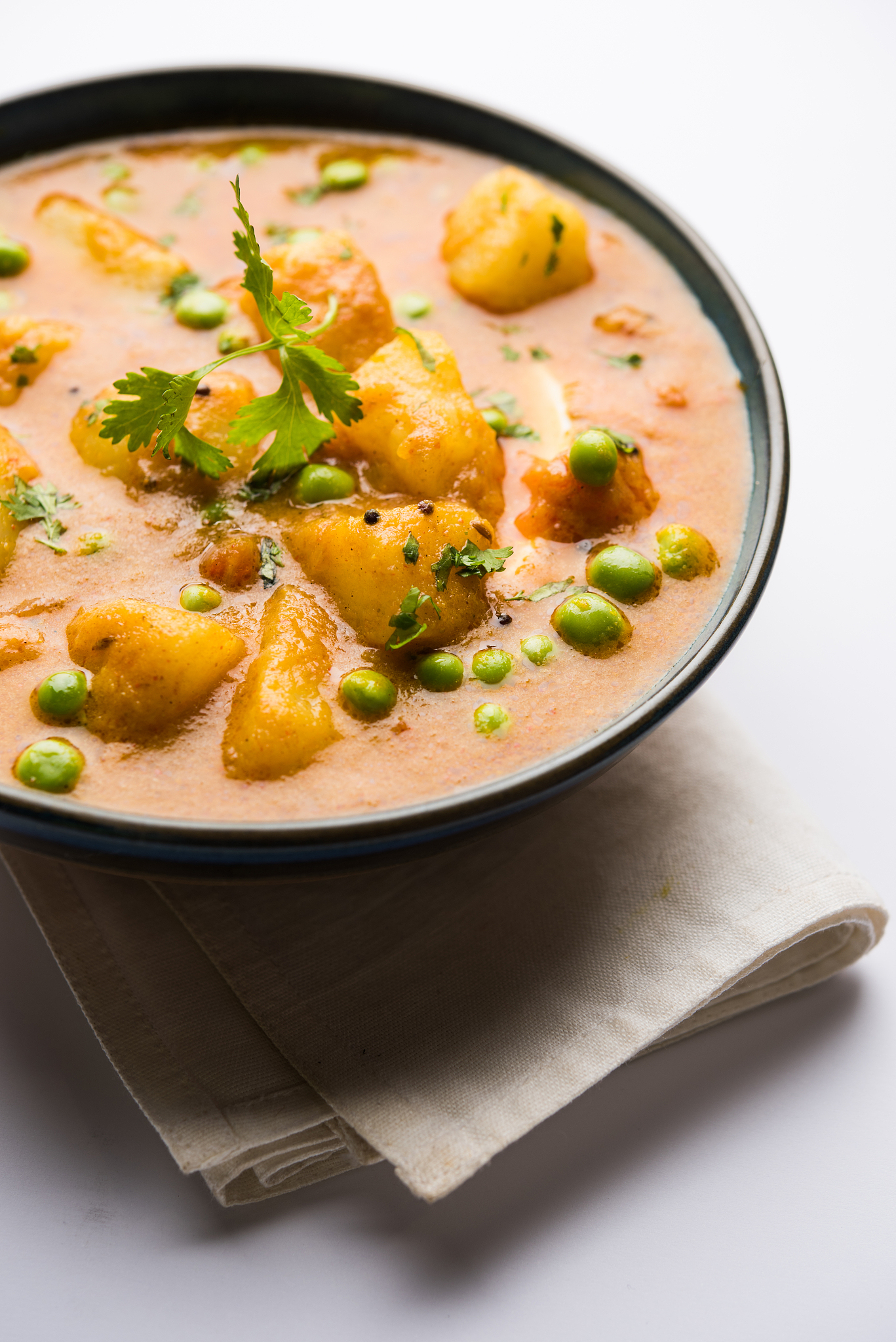 indian aloo mutter curry - potato and peas immersed in an onion 
