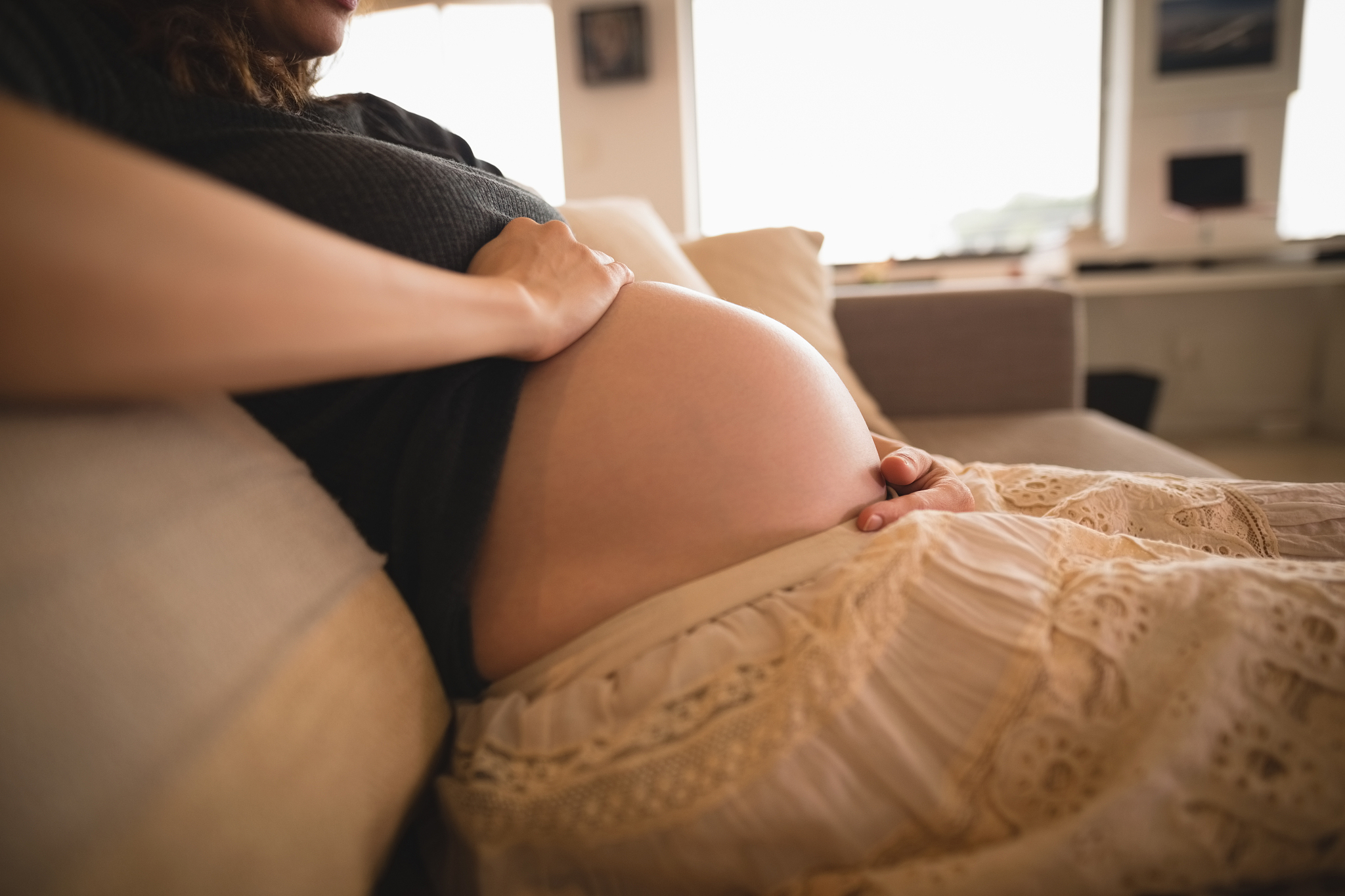 pregnant woman sitting on the couch