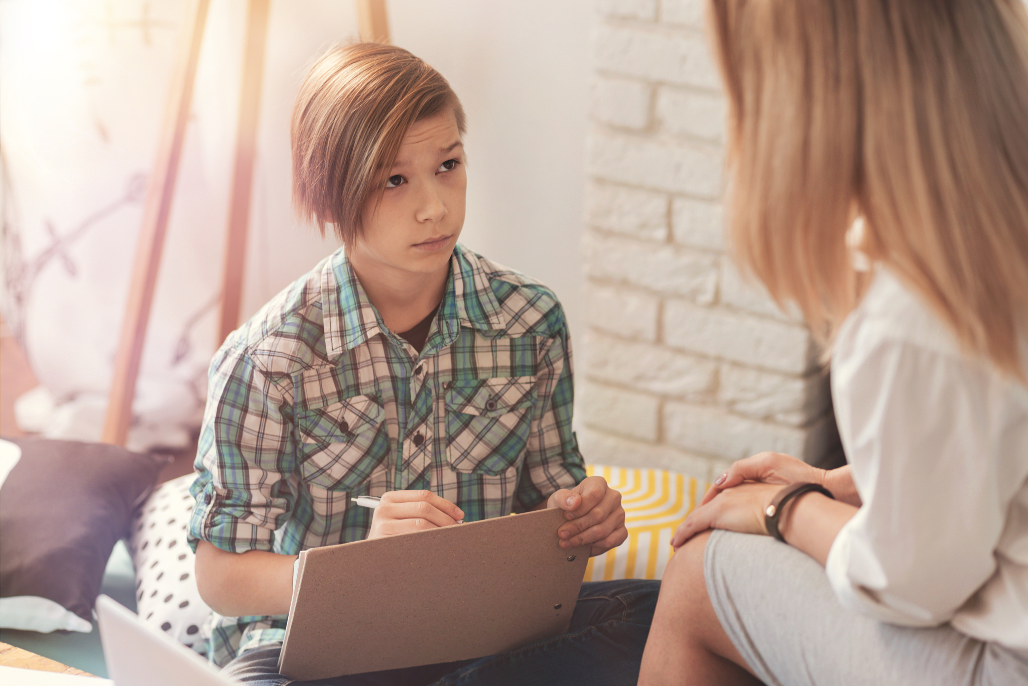 troubled schoolboy having a session with a female psychologist