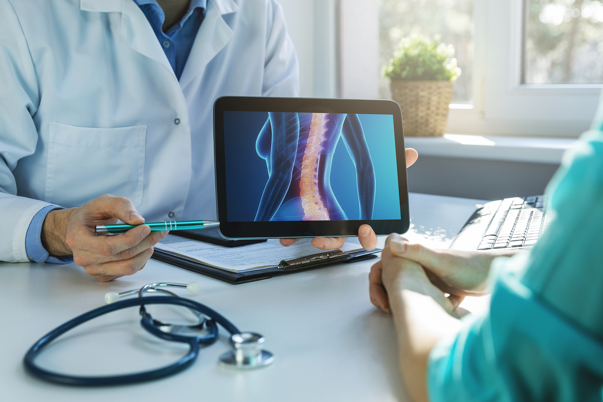 doctor and patient talking about back pain treatment in clinic o