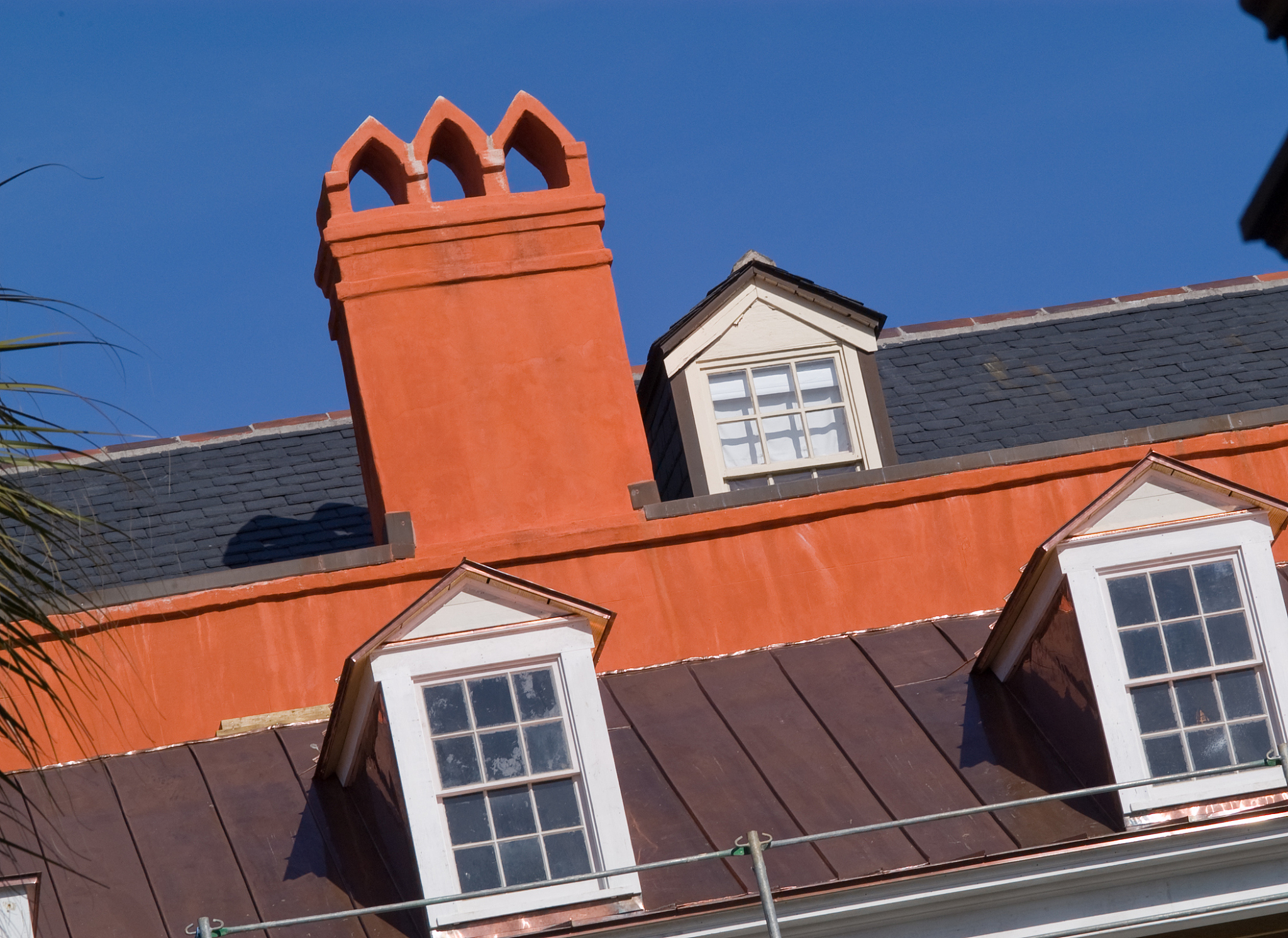 将以下文字变得通顺：但是有一个可能啊就是镜头导致的。比如你你站在车的这个位置你拍这个房子那有可能就歪斜了。但是这个可能我有点判断不了这个不说了哈反正就是一个歪有点歪斜的一个世界吧。呃从视觉连续性来说这个房子左边有一个斜的斜的线然后那个右边的那个房子就是摊出一角那个房子那个屋檐也有个斜的线车身也有个左侧的这个斜线和车屁股那个一个斜线整个就处于这些东西。然后那个电杆切出那切出一个小条那个条的宽度跟那个