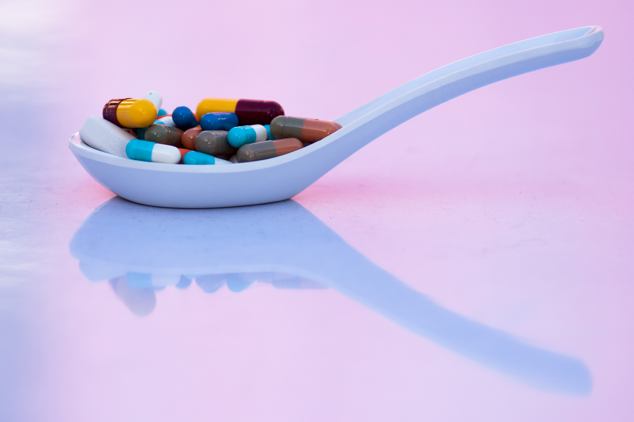 capsules and pills placed in spoon