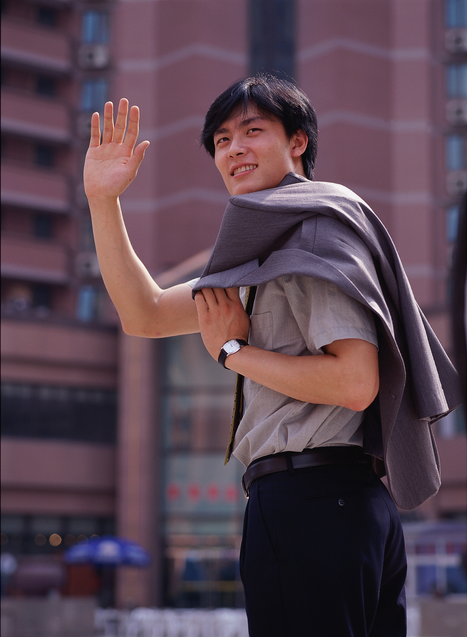 东方男人在户外站着招手