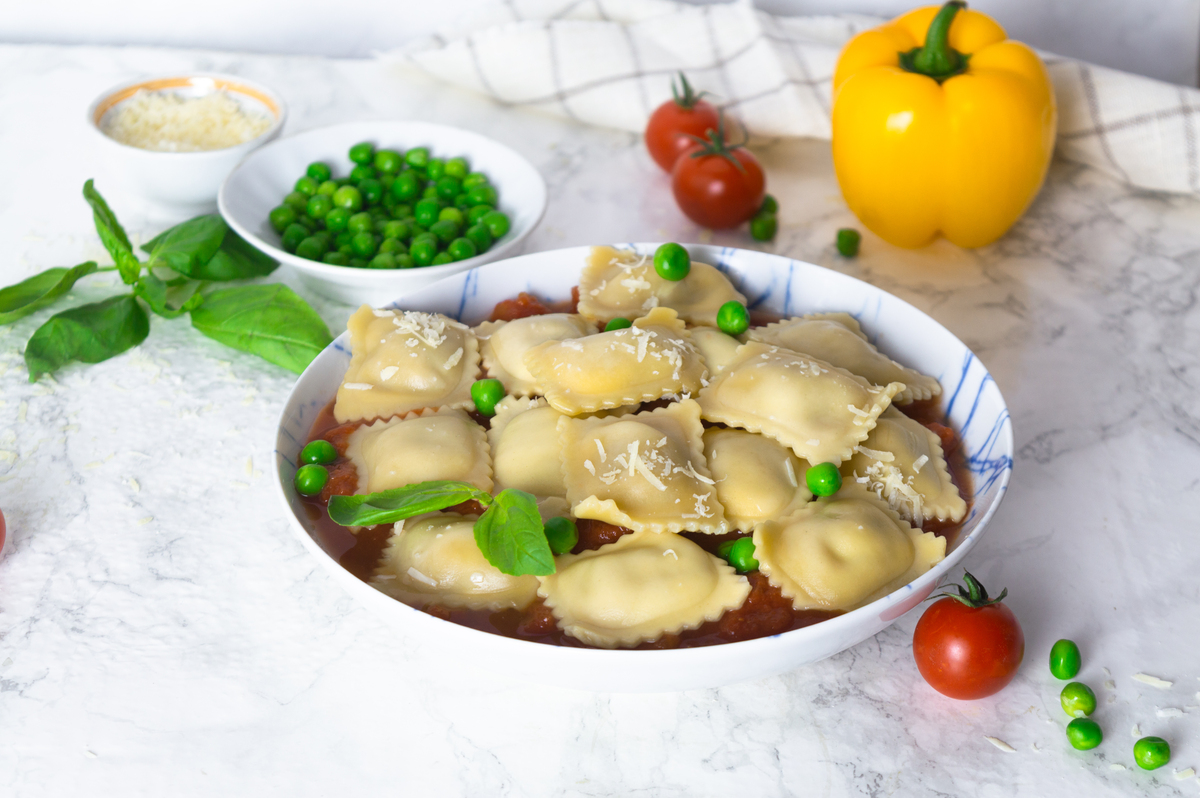 肉馅饺子配番茄酱和青豌豆