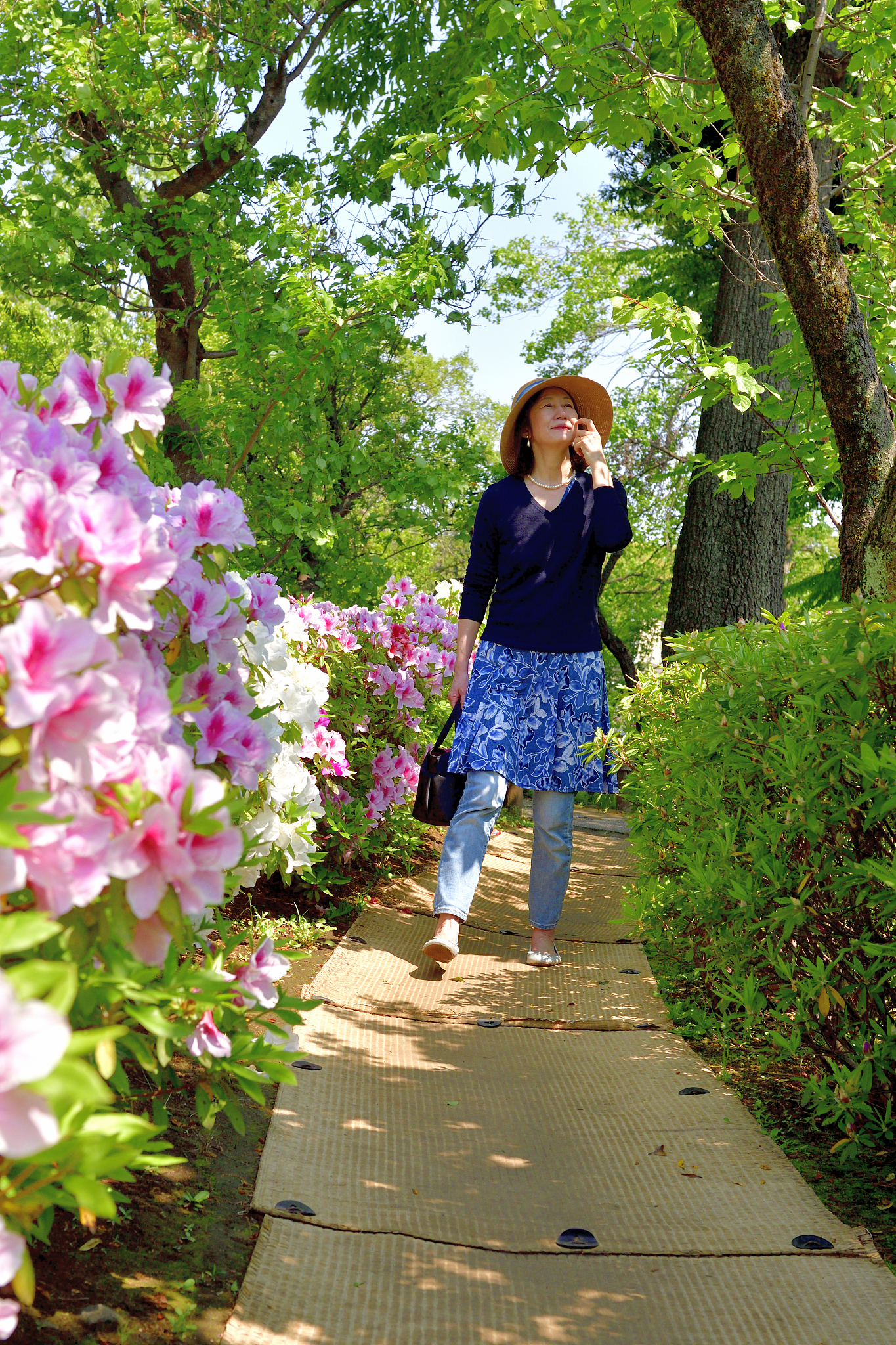 japanese woman enjoying walking in tokyo public park with azalea