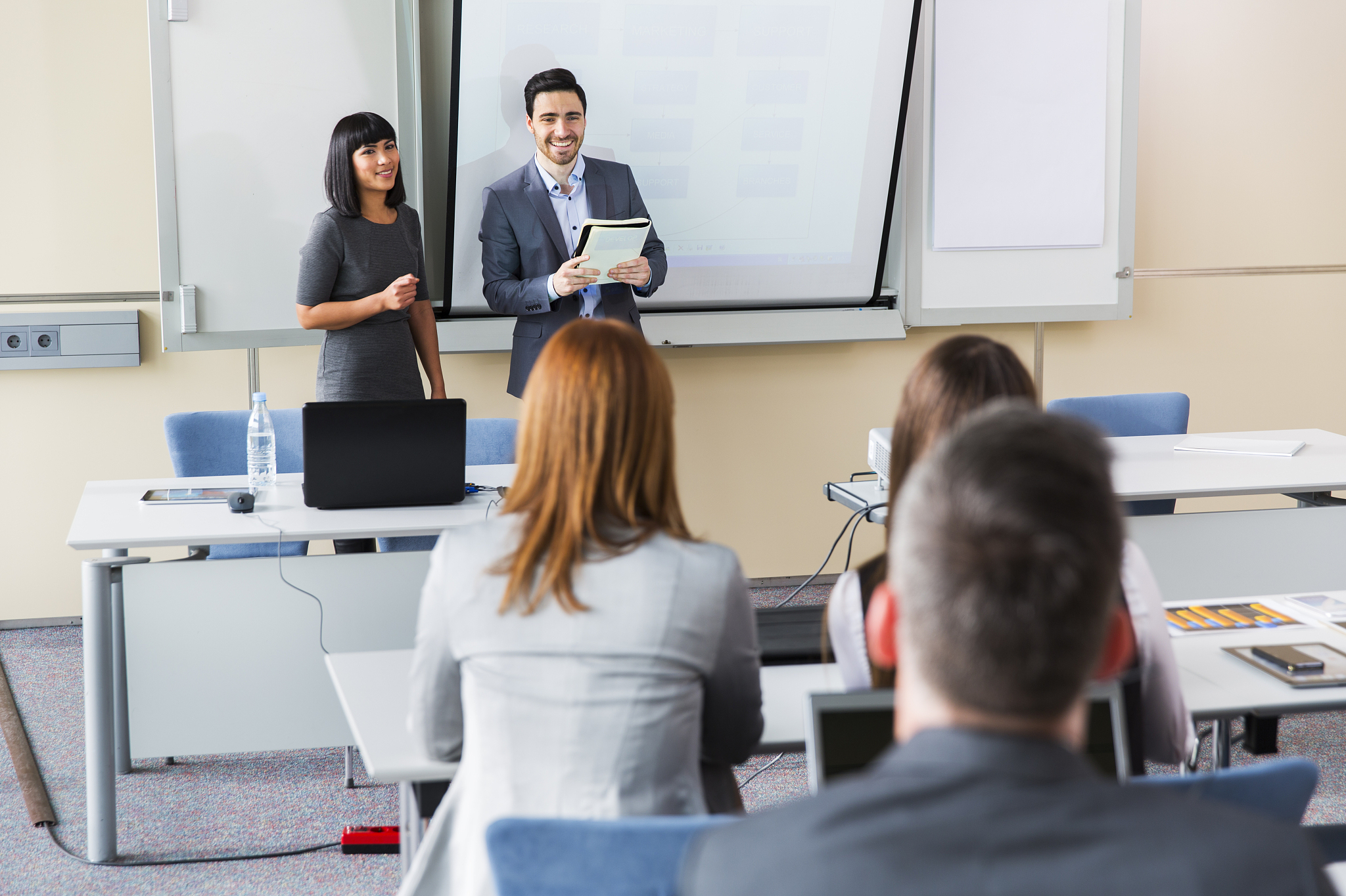 business people in education room listening couple of young lect