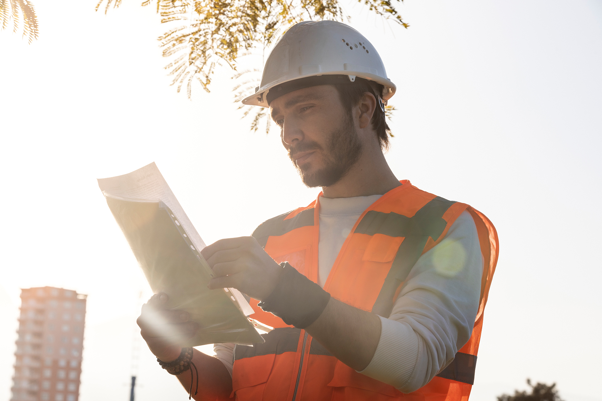 construction engineer controlling datasheet and wearing safety h