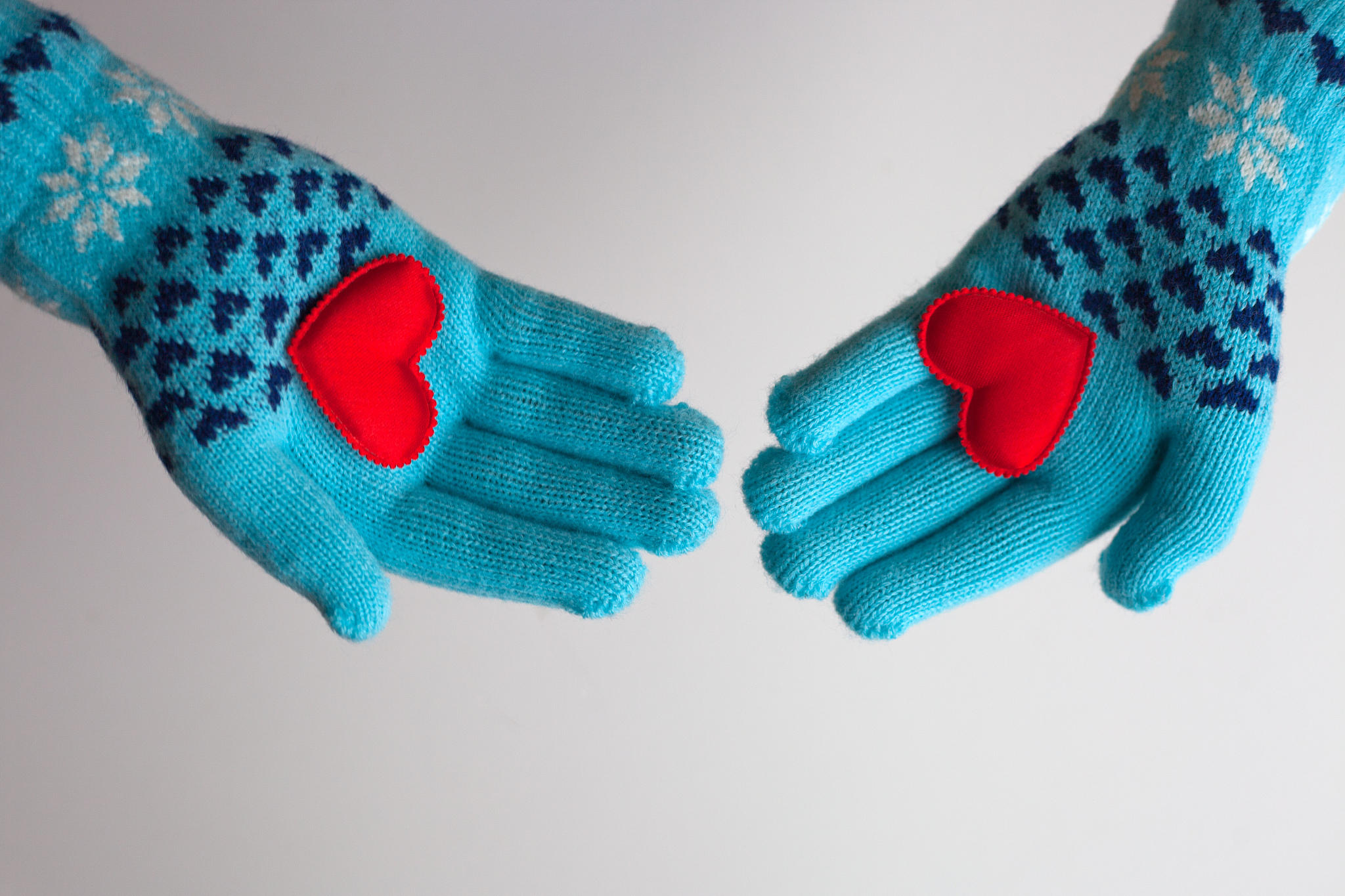 red hearts in hands in warm gloves for valentine's day