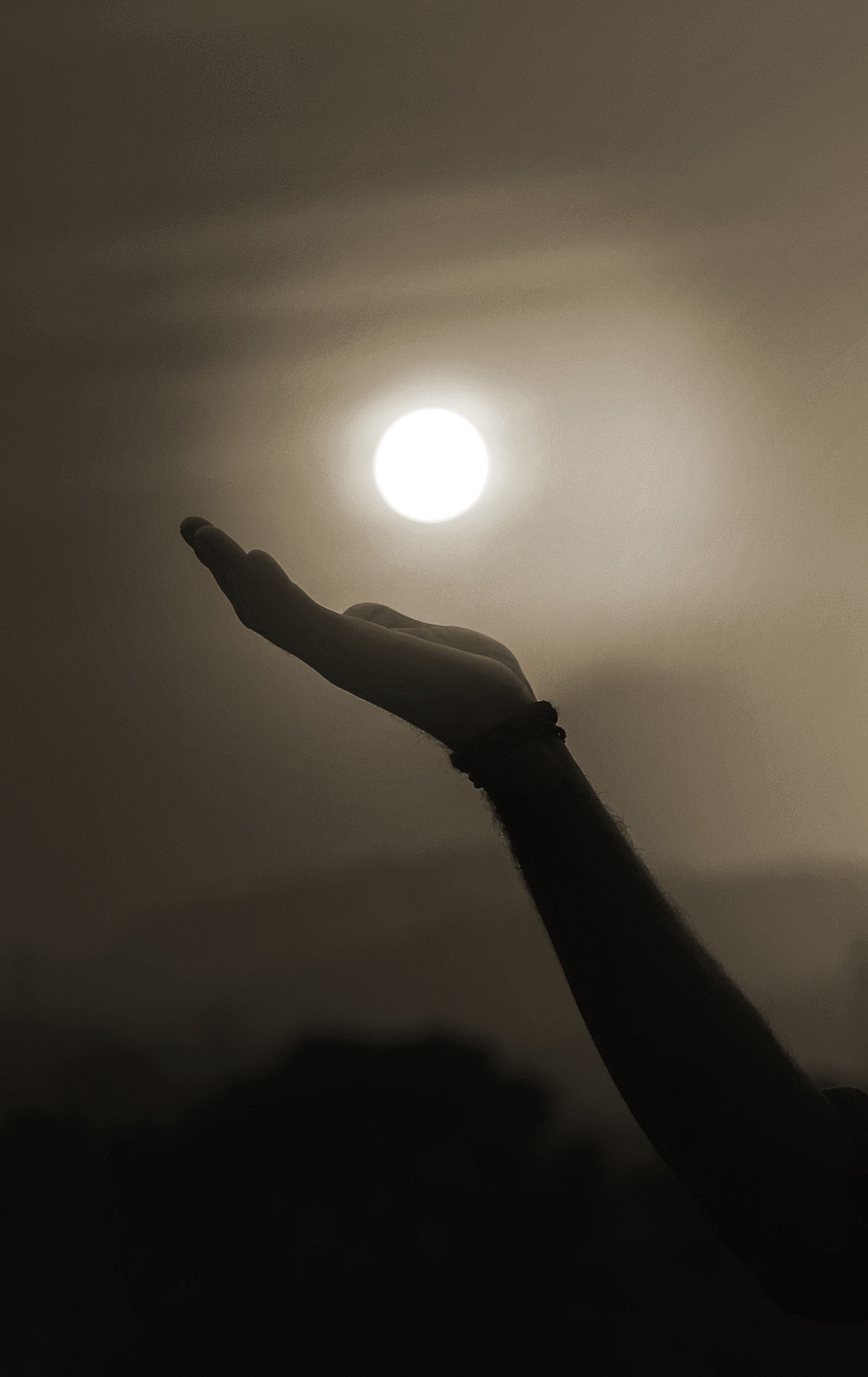 optical illusion of mature man holding sun against sky during su