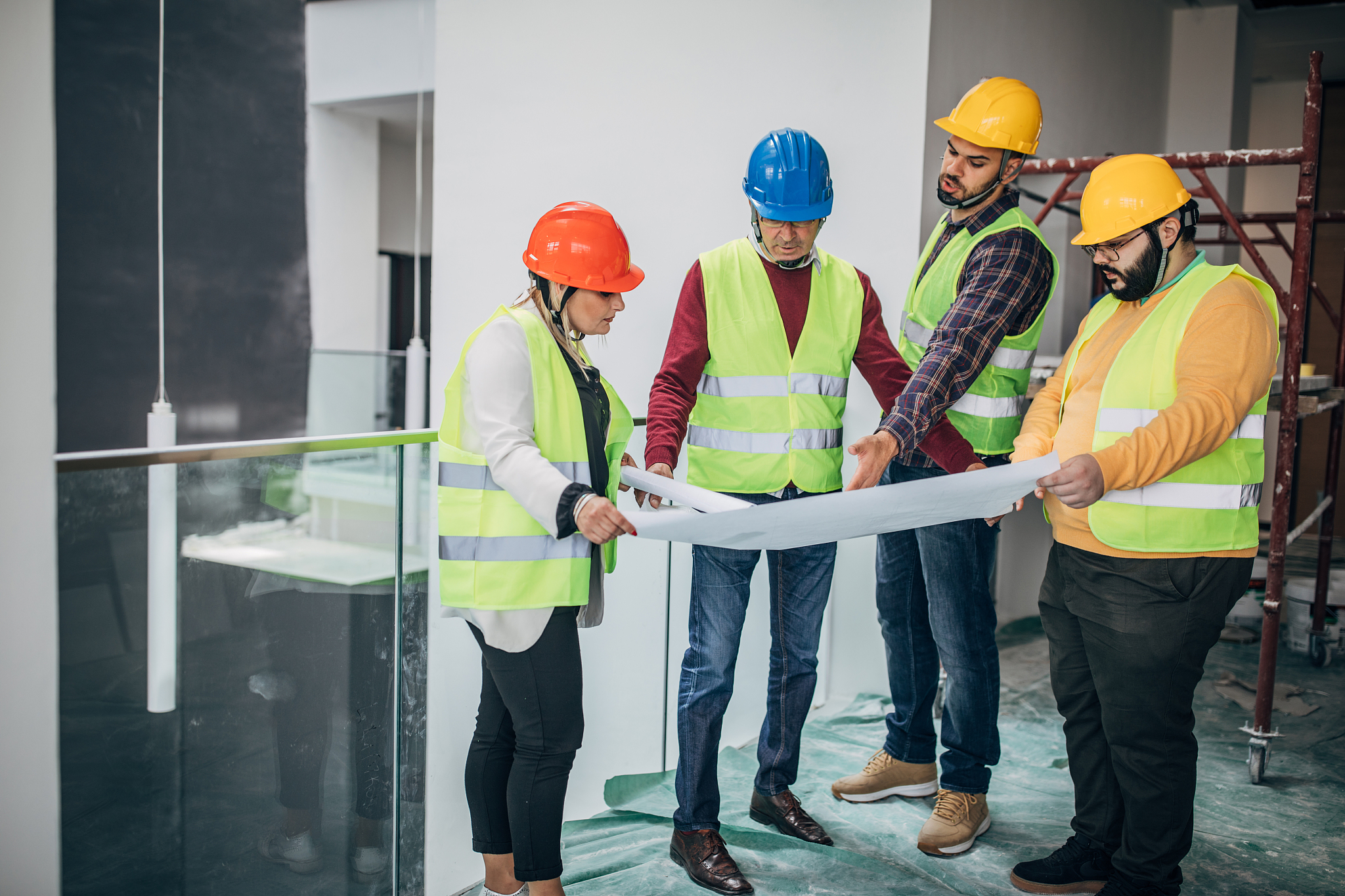 engineers and architects looking at building blueprint at the co