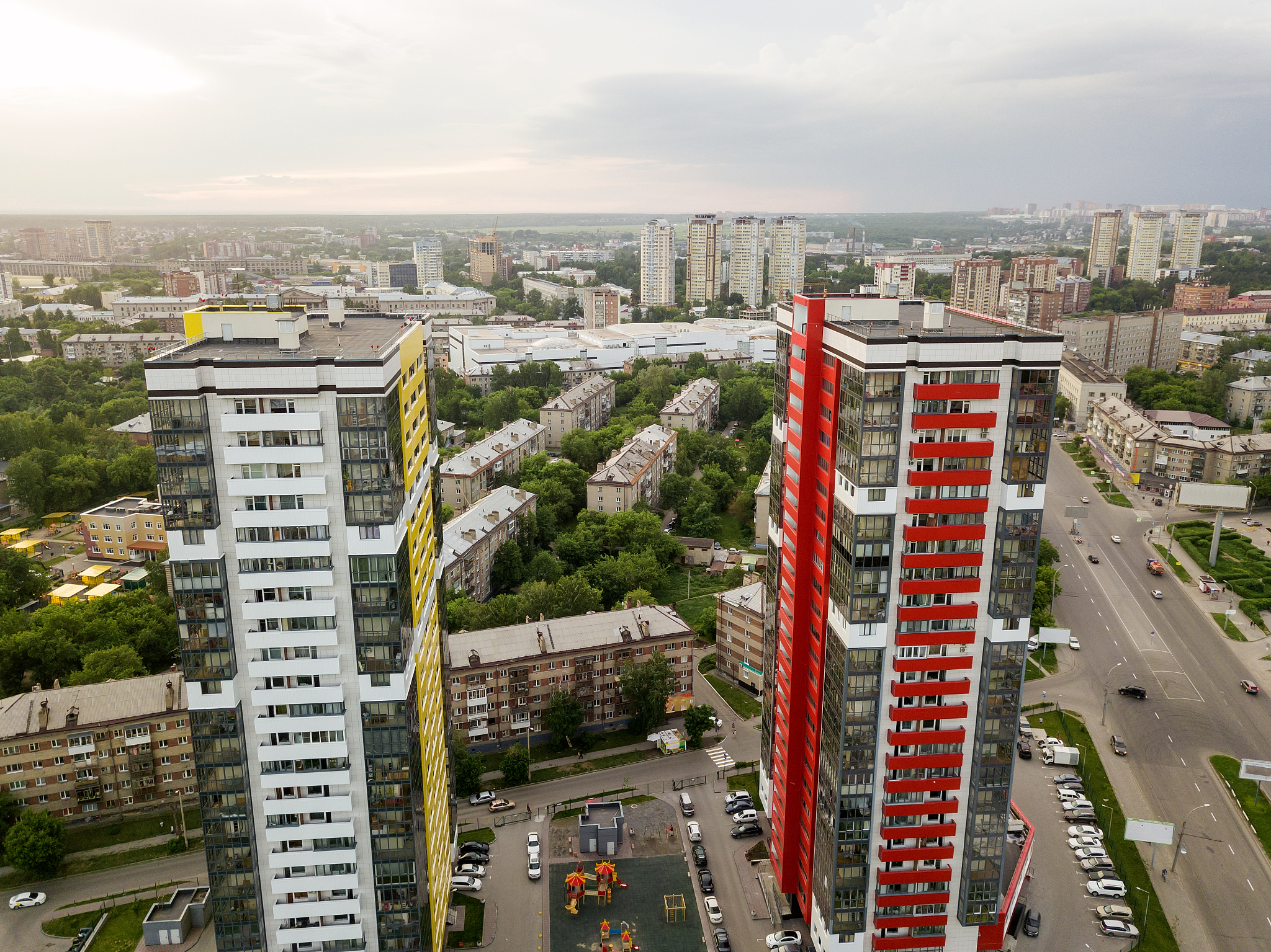 aerial view of landscape with two tall skyscrapers of red and ye