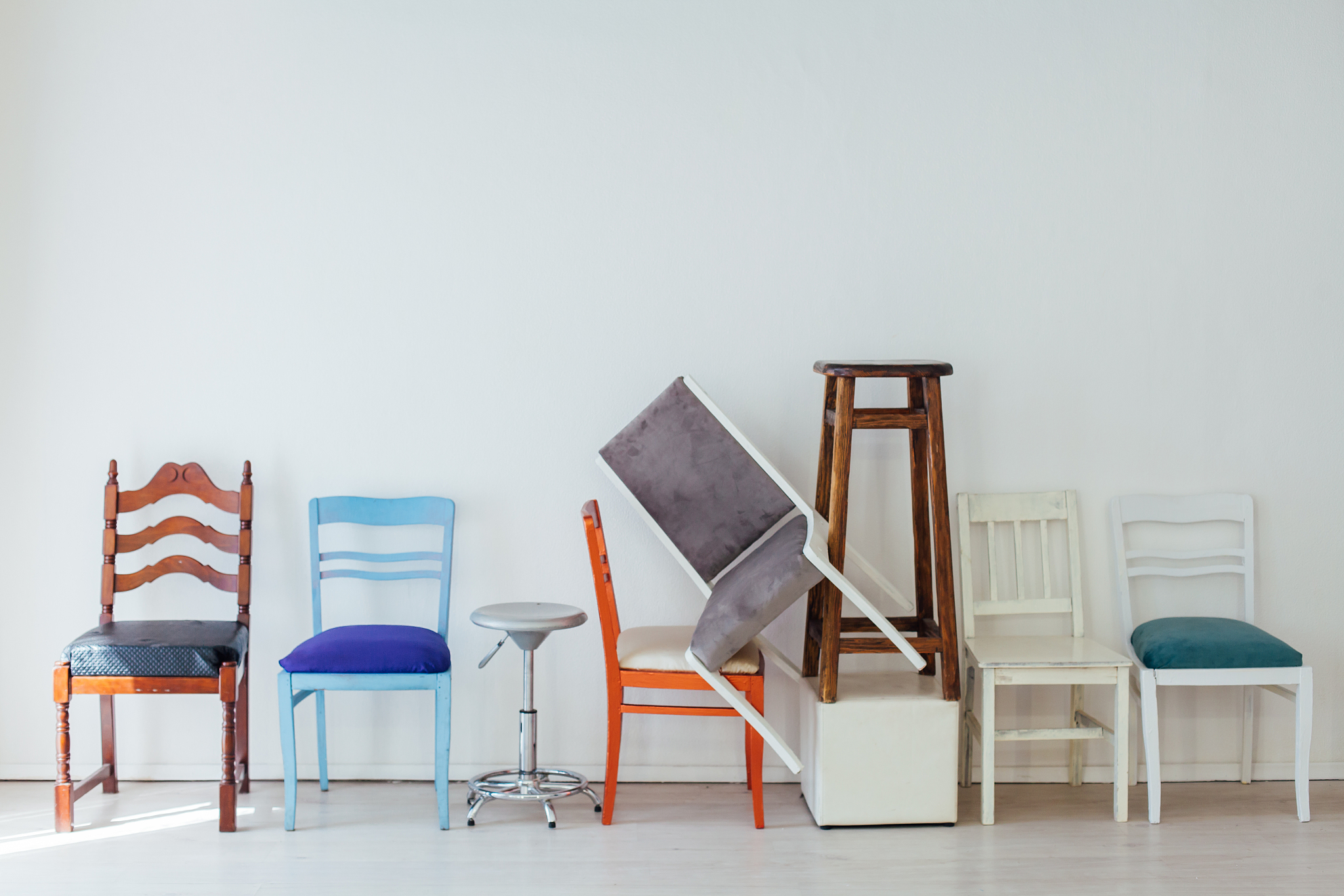 many multicolored chairs in the mess of the white room