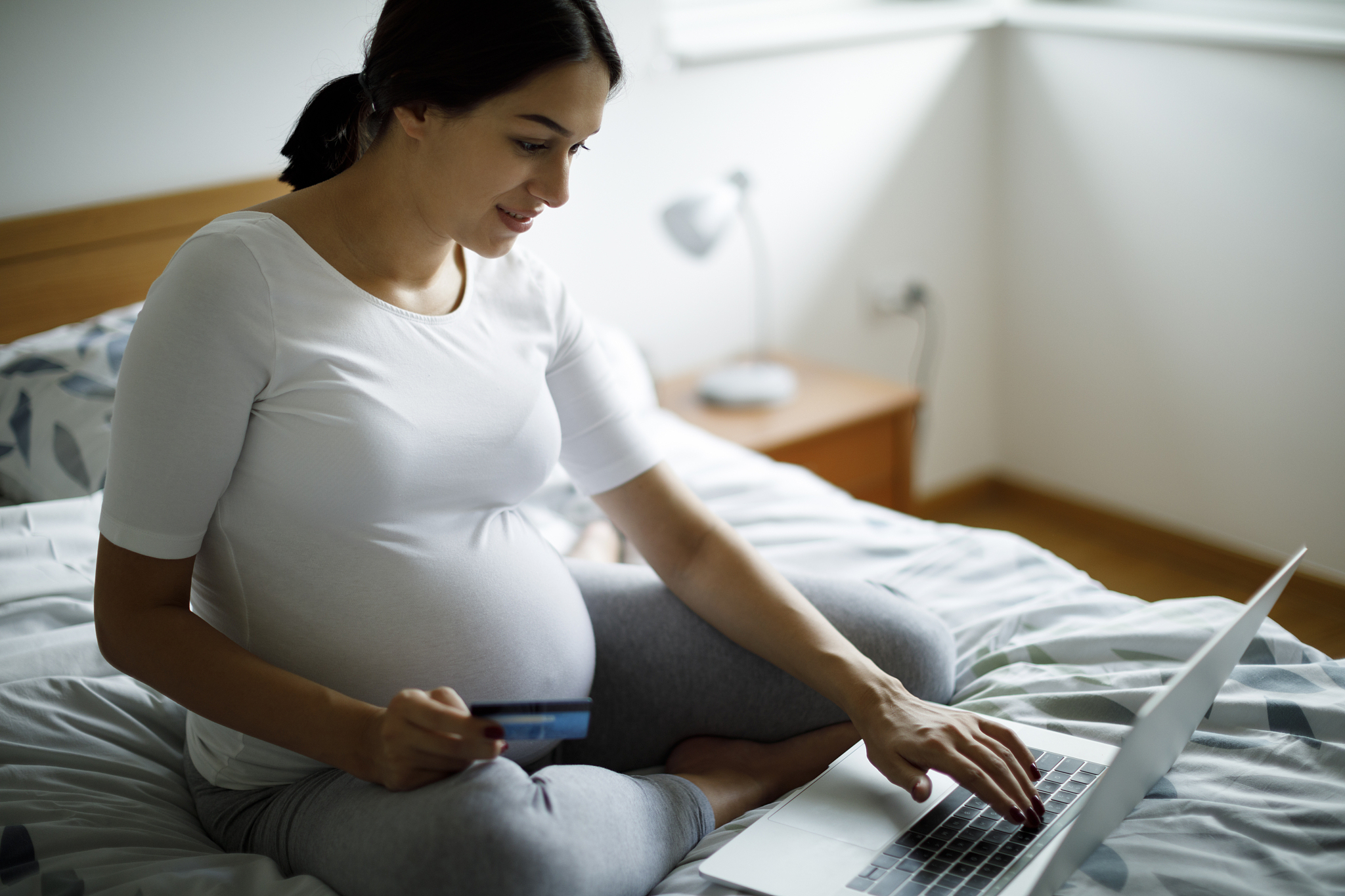 young pregnant woman shopping online with credit card
