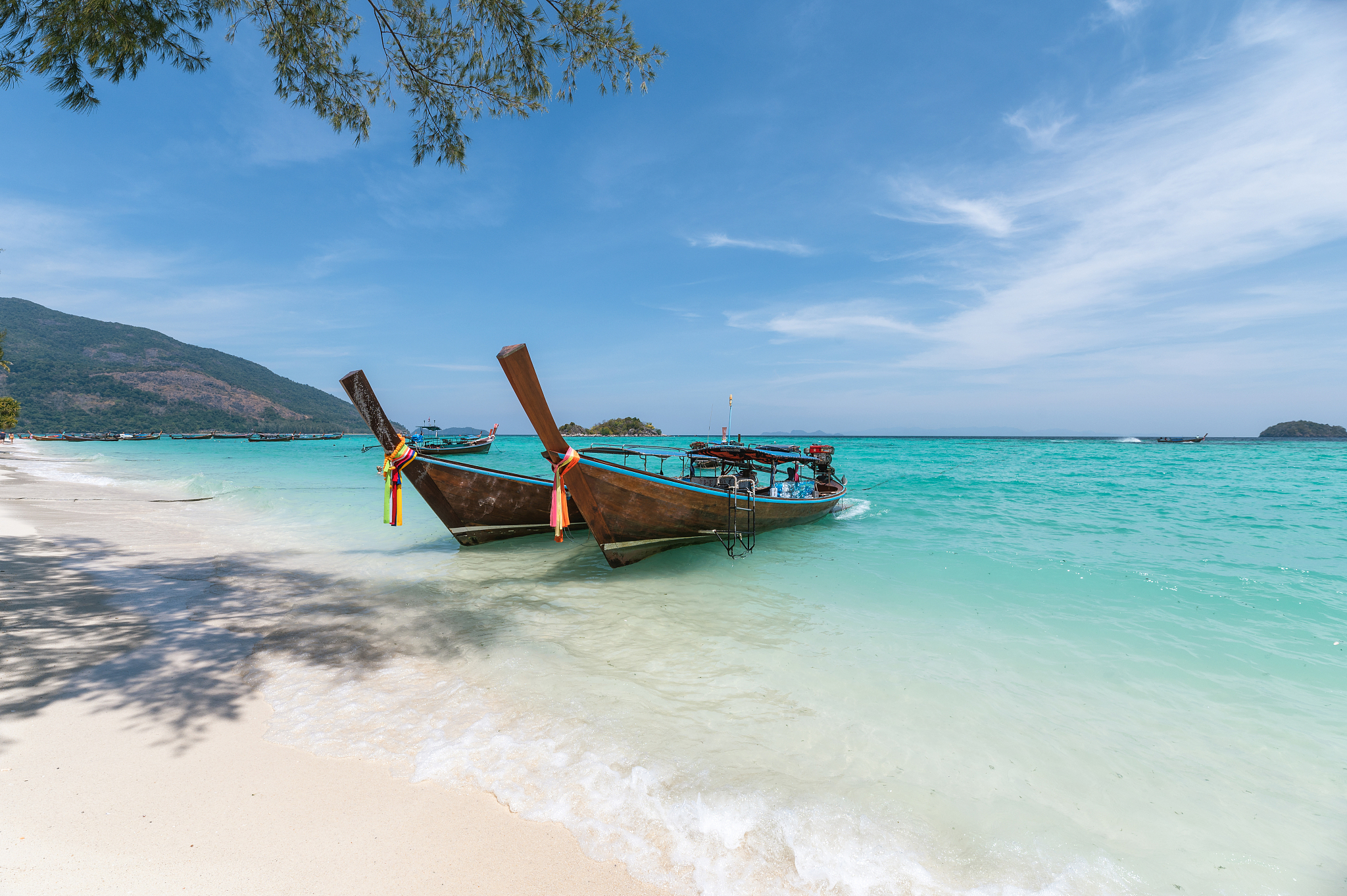 wooden long-tail boats on crystal tropical sea