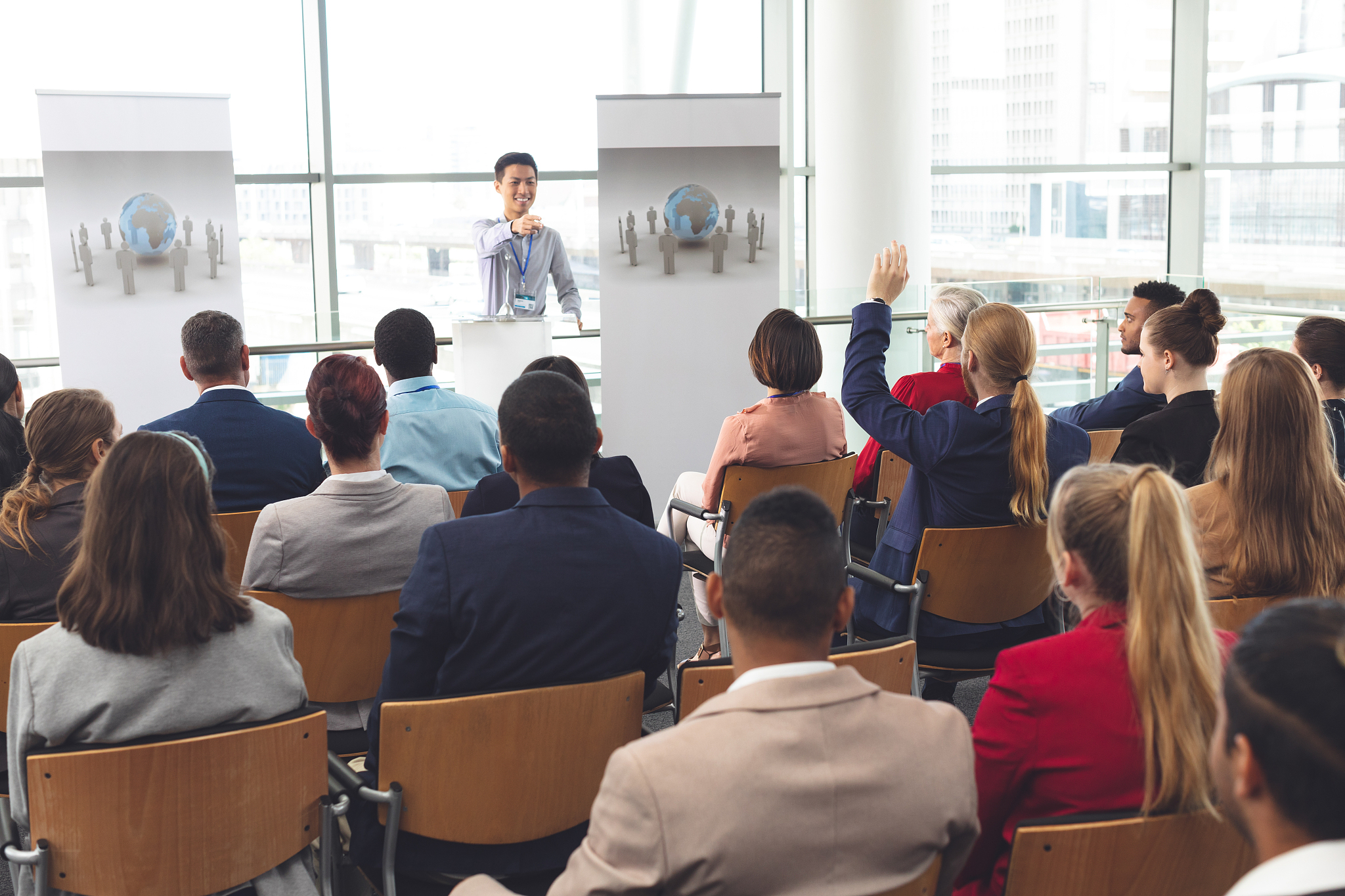 businessman raising hand in a business seminar