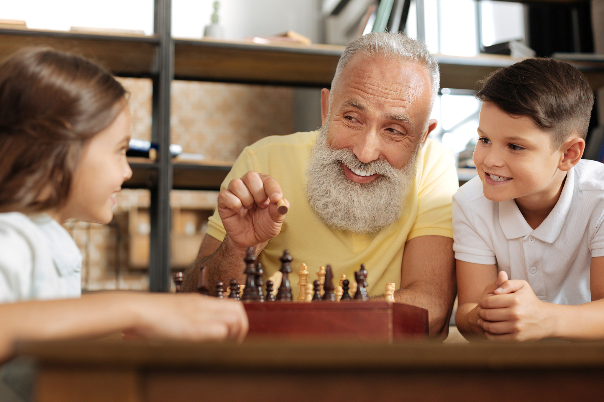 grandfather explaining chess rules to his grandchildren