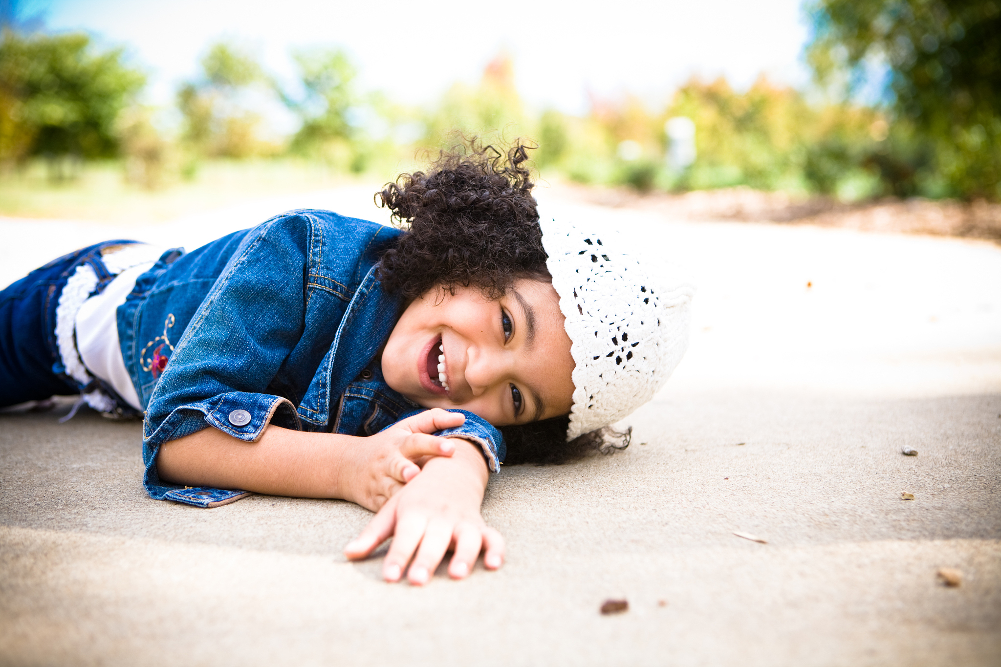 little girl laughing laying on ground